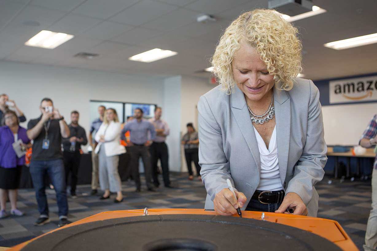 Salt Lake City Mayor Jackie Biskupski signs a robot that will be used at Amazon's new Utah fulfillment center in Salt Lake City on Monday, Aug. 13, 2018. The 855,000-square-foot facility will employ over 1,500 full-time workers, shipping smaller items to customers. (Photo: James Wooldridge, KSL)