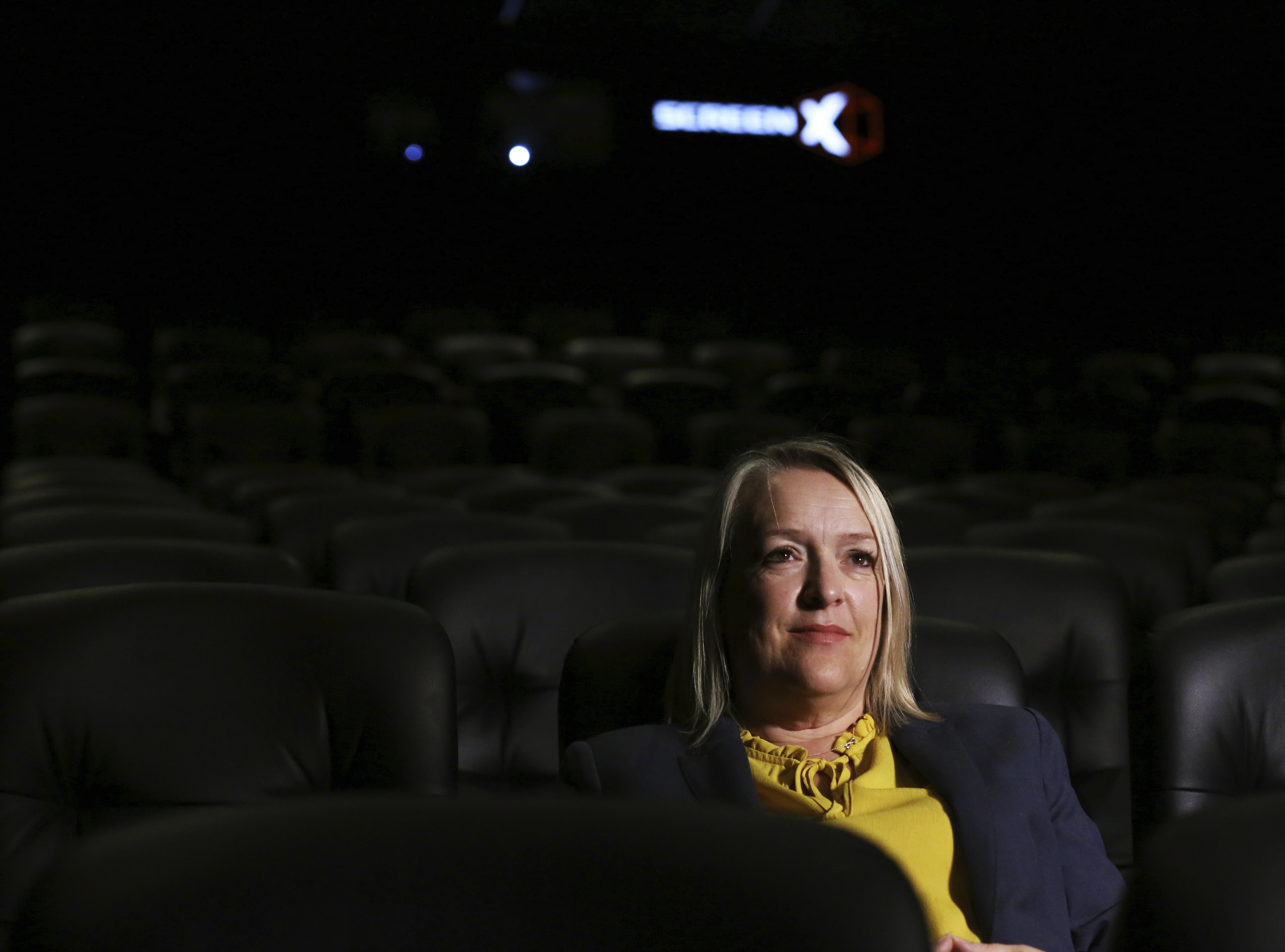 In this photo taken on Thursday, Aug. 9, 2018, Kelly Drew, an operations director at Cineworld, sits in the front row at Cineworld during a demonstration of ScreenX, a technology that projects films onto three screens, in London. Photo: Robert Stevens, AP Photo