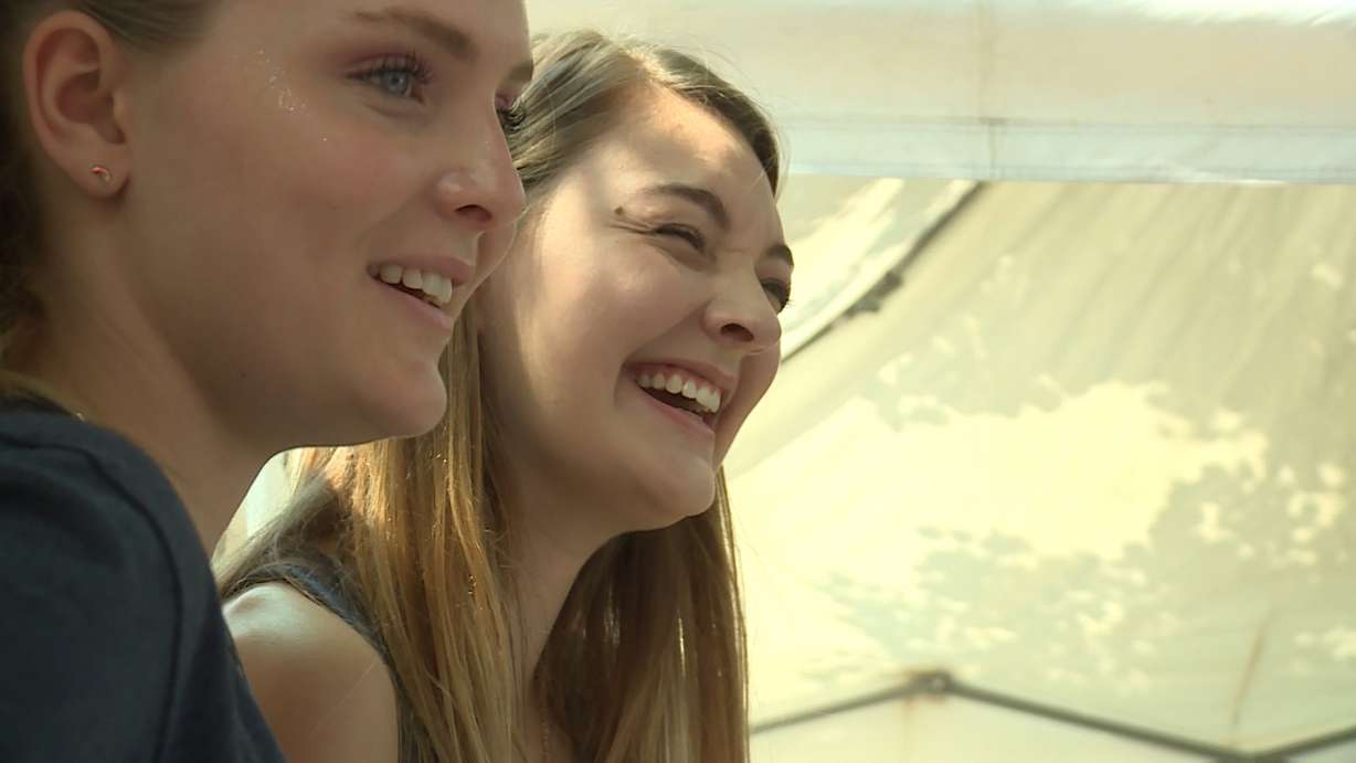 Two women smile as they get some feedback on the importance of voting from the men at the "Old Coots" booth in Salt Lake City's Pioneer Park Saturday, Aug. 18, 2018. (Ray Boone, KSL TV)