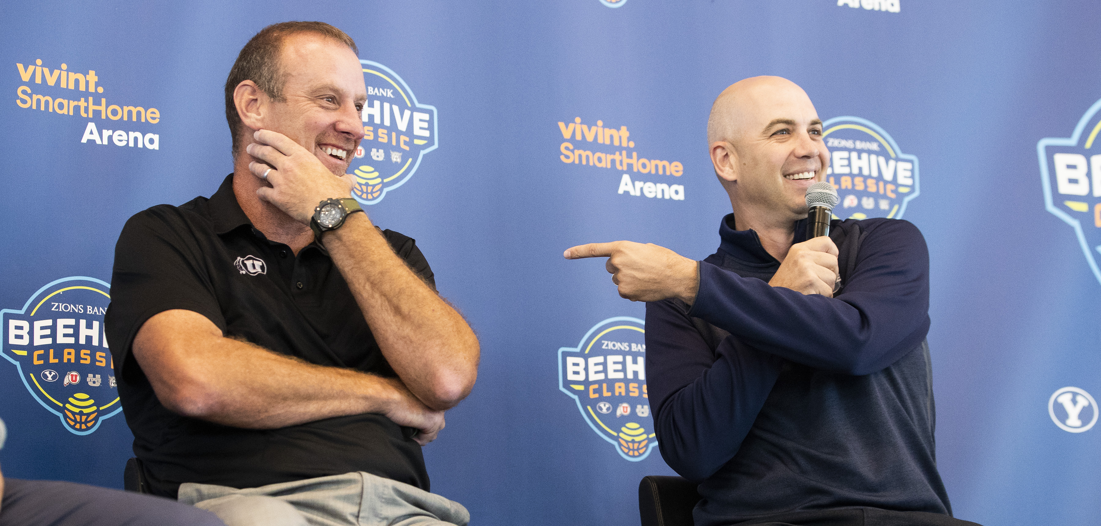 Head coaches Larry Krystkowiak, Utah, and Craig Smith, Utah State, share a laugh as they join other coaches Dave Rose, BYU, and Randy Rahe, Weber State, to promote the Beehive Classic at a press conference at Vivint Smart Home Arena in Salt Lake City on Tuesday, Aug. 21, 2018. (Photo: Scott G Winterton, KSL)