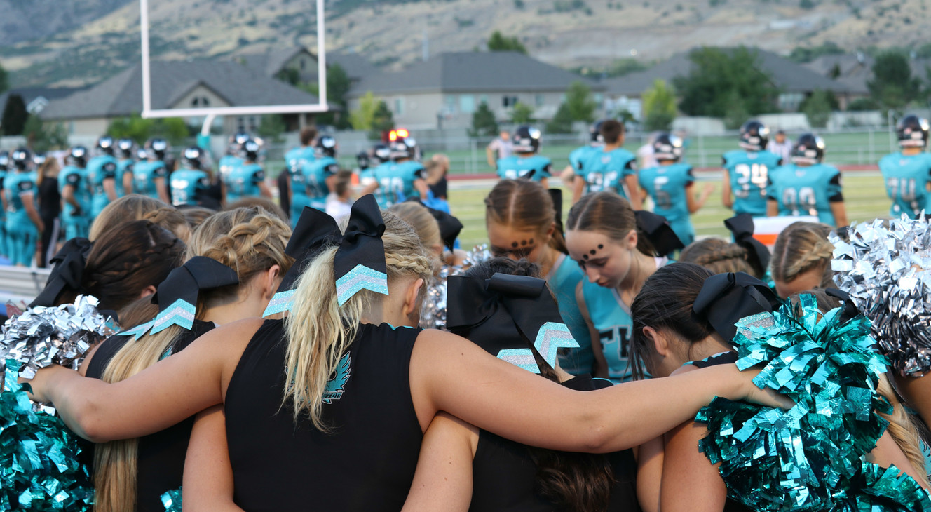 Farmington cheerleaders huddle together at the Phoenix's first-ever home football game, Friday, Aug. 25, 2018 in Farmington, Utah. (Photo: Sean Walker, KSL.com)
