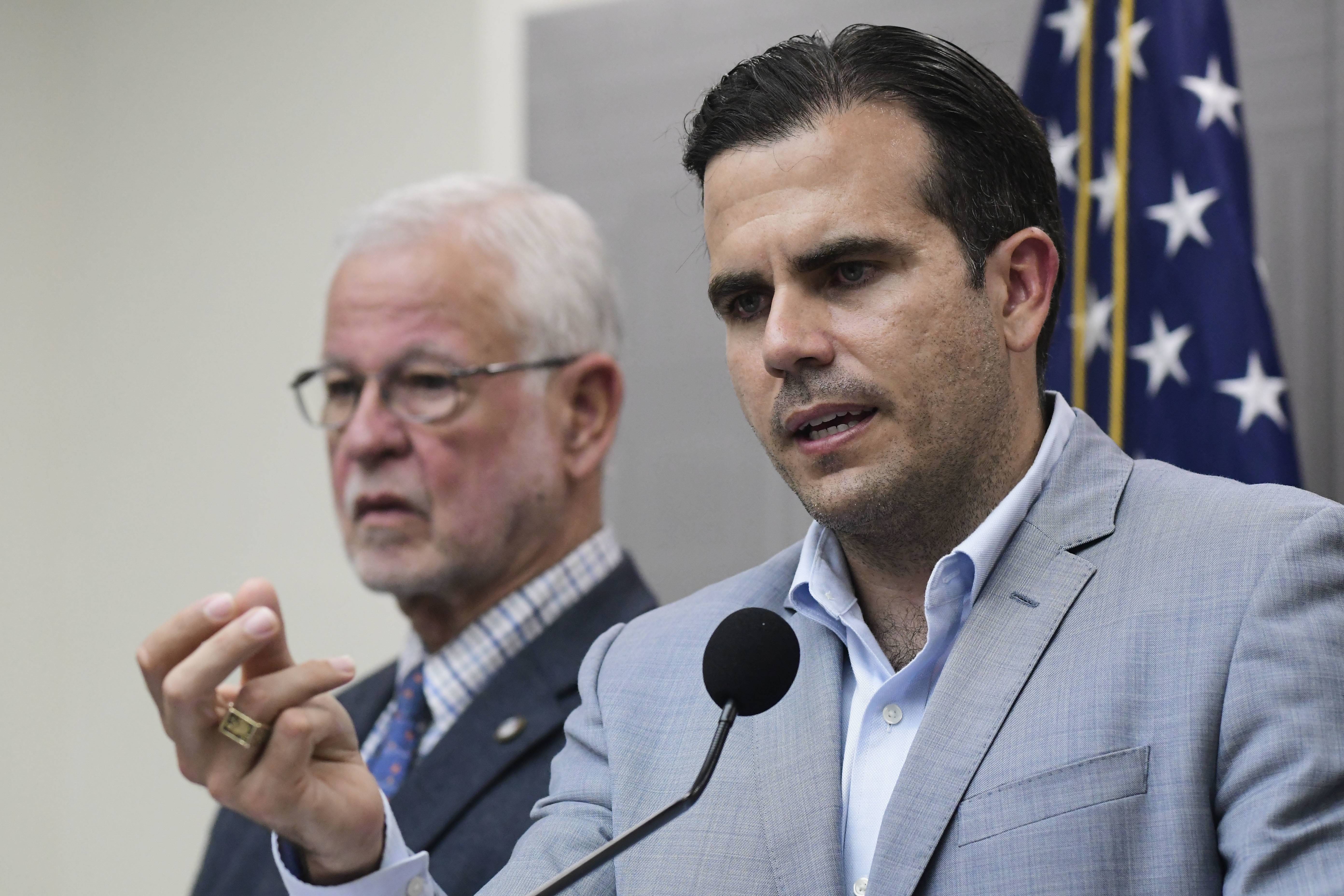 Flanked by Public Safety Secretary Hector Pesquera, Puerto Rico Gov. Ricardo Rossello speaks during a press conference regarding the number of estimated deaths in the aftermath of Hurricane Maria, in San Juan, Puerto Rico, Tuesday, Aug. 28, 2018. Rossello has raised the island's official death toll from Maria from 64 to 2,975 after an independent study found that the number of people who succumbed after the storm had been severely undercounted. (AP Photo/Carlos Giusti)