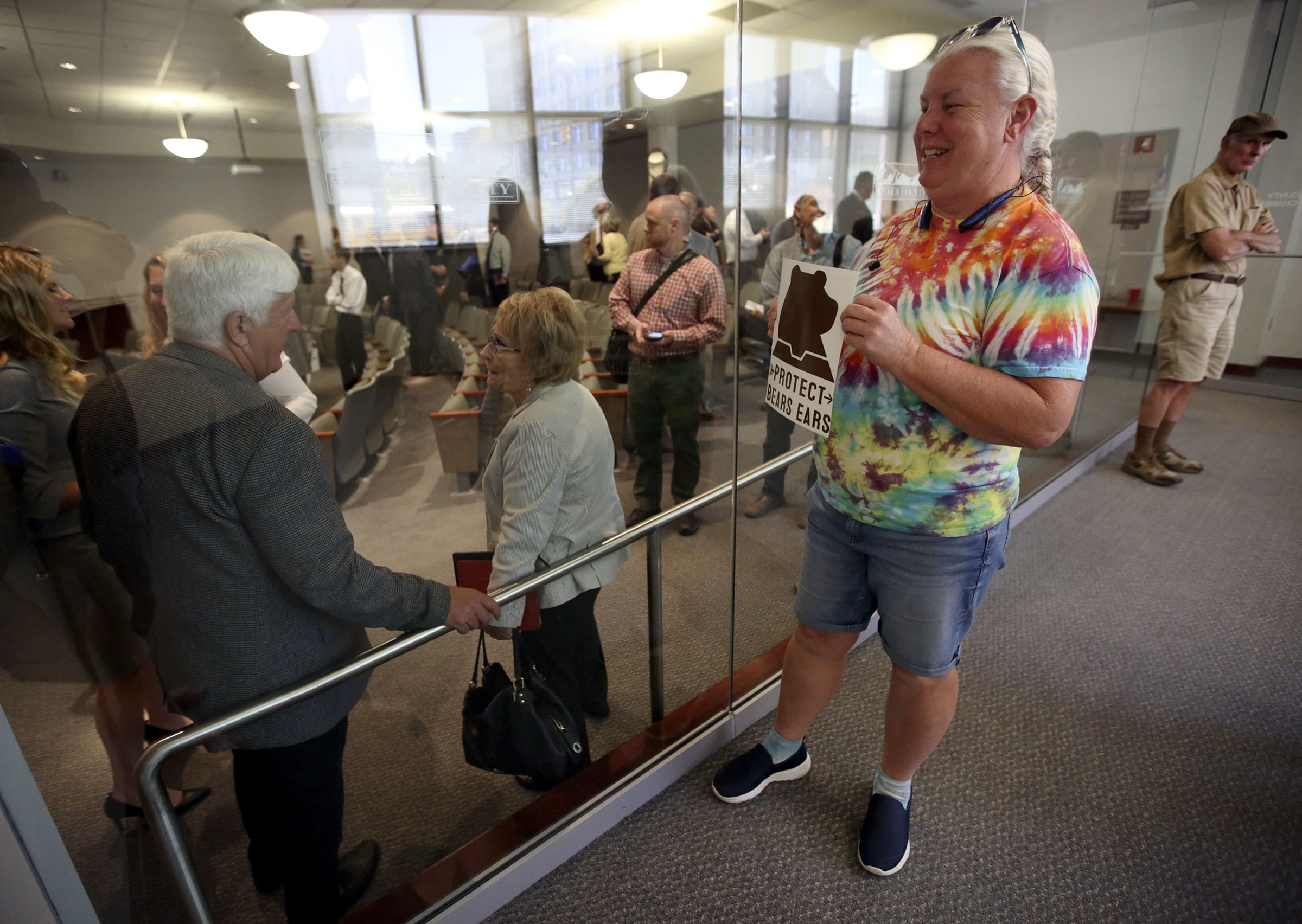 Pam Harrison tries to get the attention of Rep. Rob Bishop with a Protect Bears Ears sign after a roundtable discussion at the Ogden-Weber Chamber of Commerce in Ogden, Utah, on Tuesday, Aug. 28, 2018. (Kristin Murphy/The Deseret News via AP)