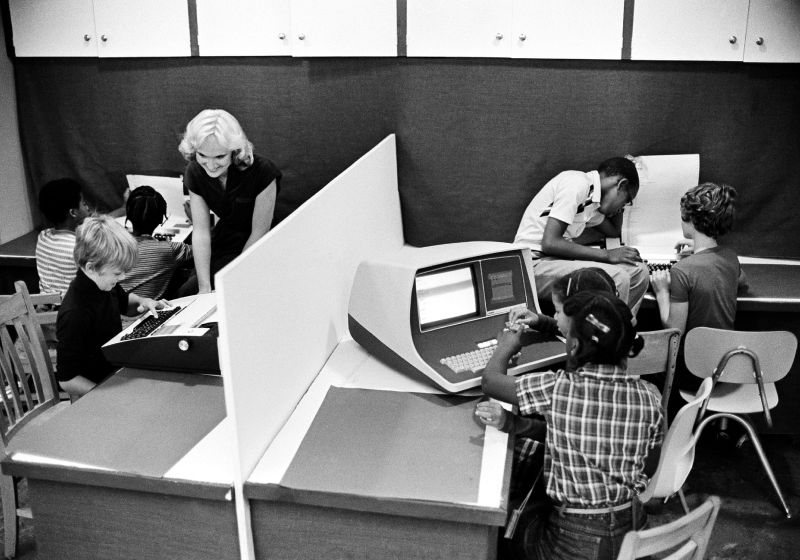 FILE- In this Oct. 5, 1980, file photo, Nancy Armstrong, a teacher at the Marshall elementary school in Harrisburg, Pa., assists her students in the use of computers to aid them in their studies. Today’s grandparents may have fond memories of the “good old days,” but history tells us that adults have worried about their kids’ fascination with new-fangled entertainment and technology since the days of dime novels, radio, the first comic books and rock n’ roll. (AP Photo/Paul Vathis, File) - Associated Press