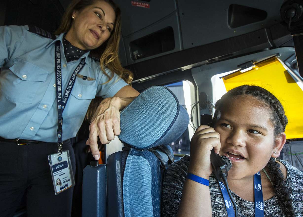 Deborah Laslo, a pilot with JetBlue, left, shows Nevaeh Tafuna how to use the communication tools inside the cockpit of an A320 aircraft during Fly Like a Girl at the Salt Lake City International Airport on Friday, Sept. 7, 2018. About 80 girls attended the event, which was aimed at introducing them to aviation and STEM careers. It was hosted by JetBlue in partnership with the Utah STEM Action Center and Atlantic Aviation. (Photo: Qiling Wang, KSL)