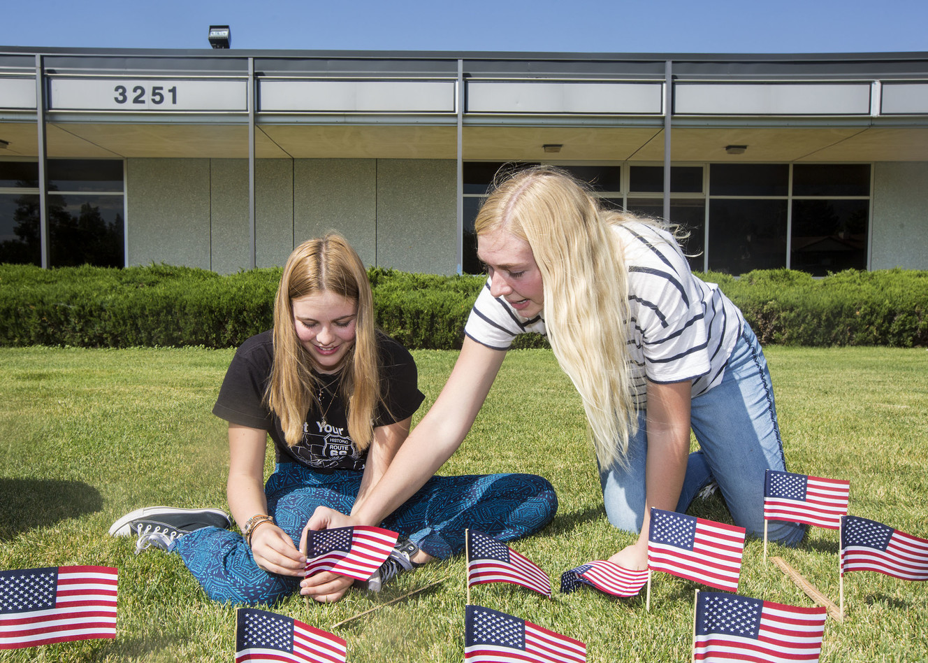 Katya Pogodaeva and Hallie Scott, founder and chairwoman of Skyline High School's chapter of Young Americans for Freedom help put up 2,977 flags in front of the Holladay school on Monday, Sept., 10, 2018, to honor the people who died in terrorist attacks on Sept. 11, 2001. (Photo: Qiling Wang, KSL)