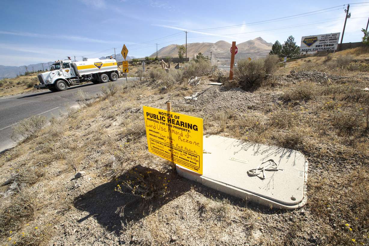 A sign advertising a public hearing is pictured as a Geneva Rock truck exits the main entrance to the company's Point of the Mountain facility on Monday, Sept. 10, 2018. Geneva is asking the Draper City Council to approve a request to expand its operation. (Photo: Scott G Winterton, KSL)