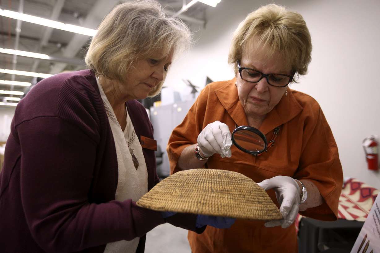 Glenna Nielsen-Grimm, anthropology collections manager at the Natural History Museum of Utah, and anthropologist Catherine Fowler look at a small coiled basket, collected by explorer John Wesley Powell, at the Natural History Museum of Utah in Salt Lake City on Thursday, Sept. 13, 2018. Photo: Kristin Murphy, KSL