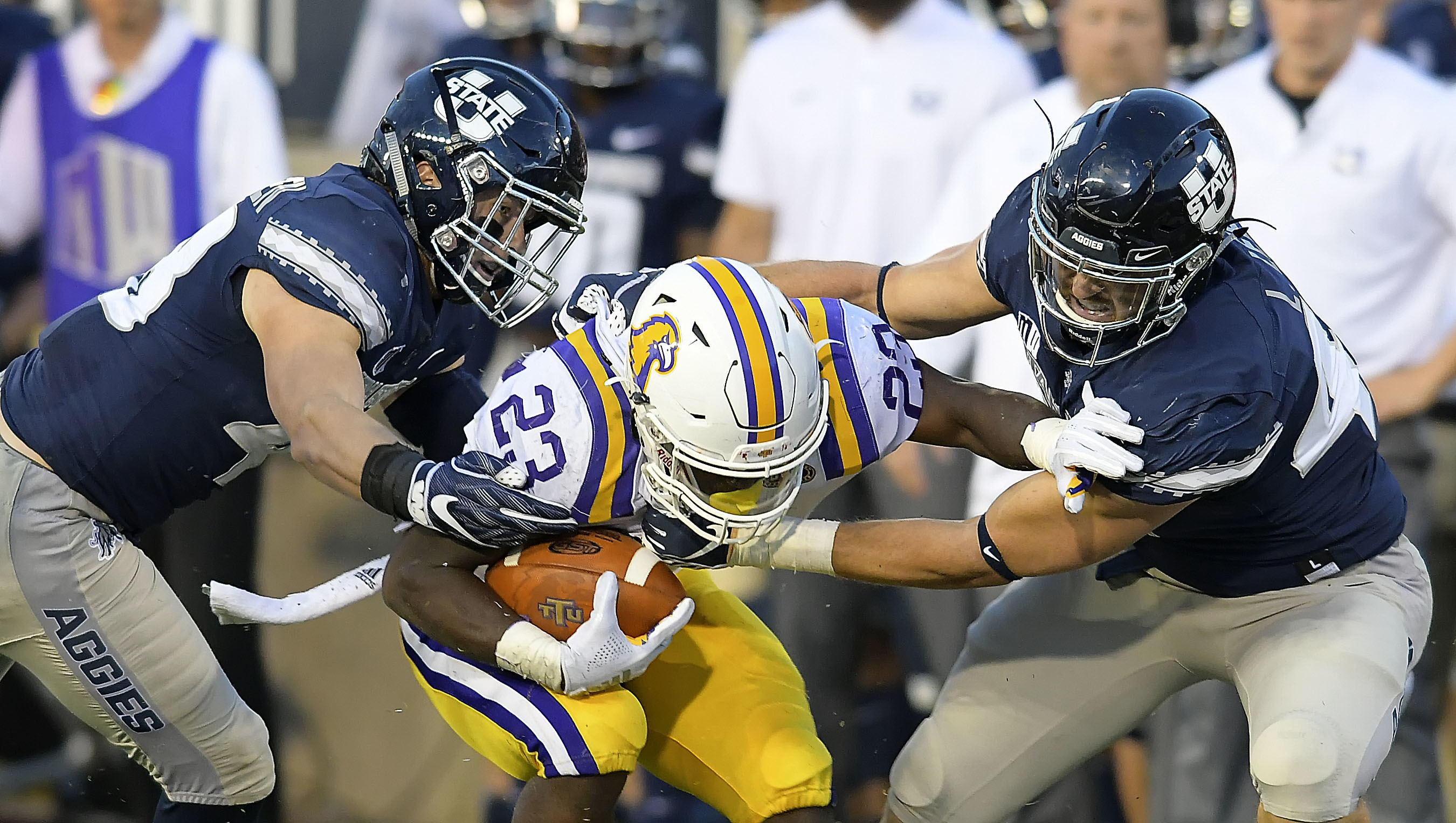 Utah State linebacker Chase Christiansen, left, and defensive end Logan Lee tackle Tennessee Tech running back Andrew Goldsmith (23) during an NCAA college football game, Thursday, Sept. 13, 2018, in Logan, Utah. (Photo: Eli Lucero, Herald Journal via AP)