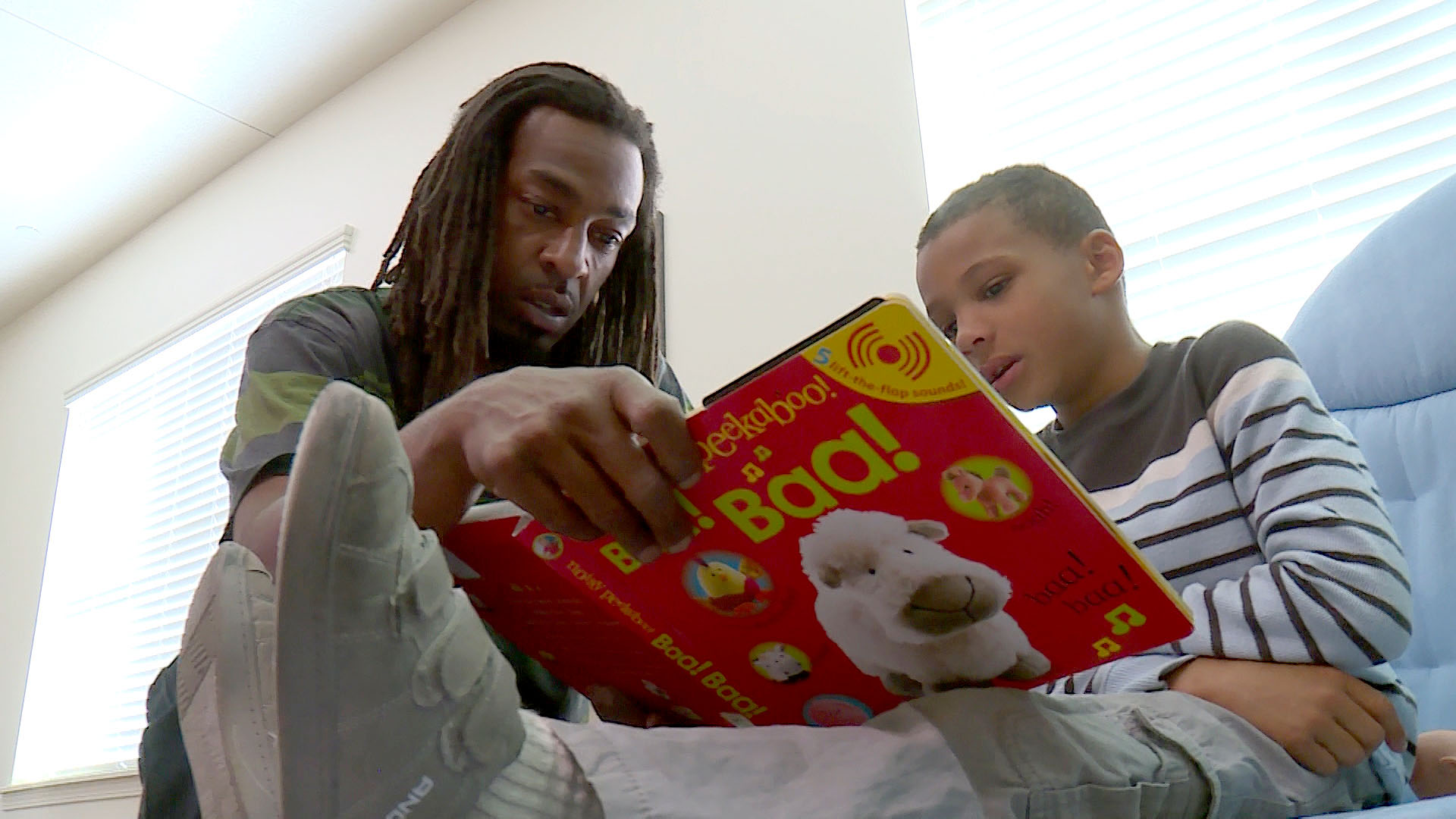 Kendrick Armstead (left) reads with his son Amari at the Lantern House homeless shelter in Ogden on Wednesday, Sept. 12, 2018. (Photo: KSL TV)
