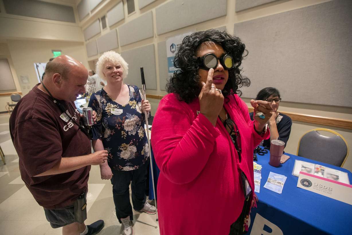 Sherry Richardson, of the Utah Department of Workforce Services in Ogden, tries out a pair of vision impairment glasses during the Deafblind Advocacy of Utah's DeafBlind Awareness Day conference at the Utah Division of Services for the Blind and Visually Impaired in Salt Lake City on Friday, Sept. 21, 2018. (Photo: Scott G Winterton, KSL)