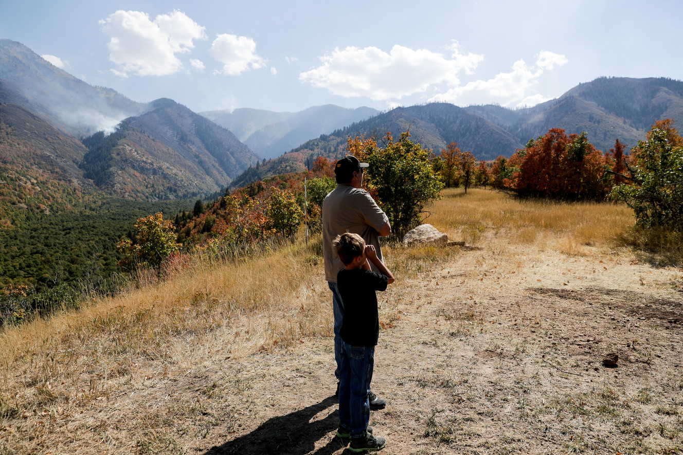 Dennis Jacobson and his grandson, Tripp Peacock, 8, look up at areas of the Bald Mountain Fire near Jacobson's home in Elk Ridge after evacuations were lifted on Saturday, Sept. 22, 2018. (Photo: Spenser Heaps, KSL)