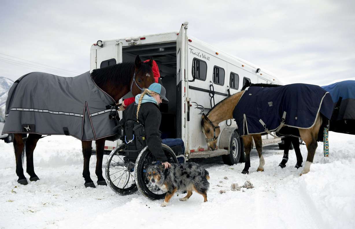 FILE - In this Jan. 3, 2017, file photo, Amberley Snyder pets her dog Ellie Mae as she and her sister, Autumn Snyder, prepare horses to ride for practice at the Spanish Fork fairgrounds in Spanish Fork, Utah. Snyder has no feeling in her legs, but the barrel-racer isn't letting that slow her down. (Isaac Hale /The Daily Herald via AP, File) (Photo: Isaac Hale, The Daily Herald)