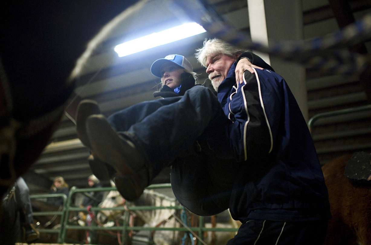 FILE - In this Jan. 7, 2017, file photo, Cory Snyder lifts his daughter Amberley up onto the saddle of her horse named Legacy, also known as French Open, before competing in the Dash for Cash barrel races at the Spanish Fork fairgrounds in Spanish Fork, Utah. Snyder has no feeling in her legs, but the barrel-racer isn't letting that slow her down. Snyder, a partially paralyzed professional barrel racer, has finished filming "Walk Ride Rodeo," slated to debut on Netflix in 2019. The film will be a dramatic portrayal of Snyder's life with a full cast of actors and actresses. (Isaac Hale /The Daily Herald via AP), File (Photo: Isaac Hale, The Daily Herald)