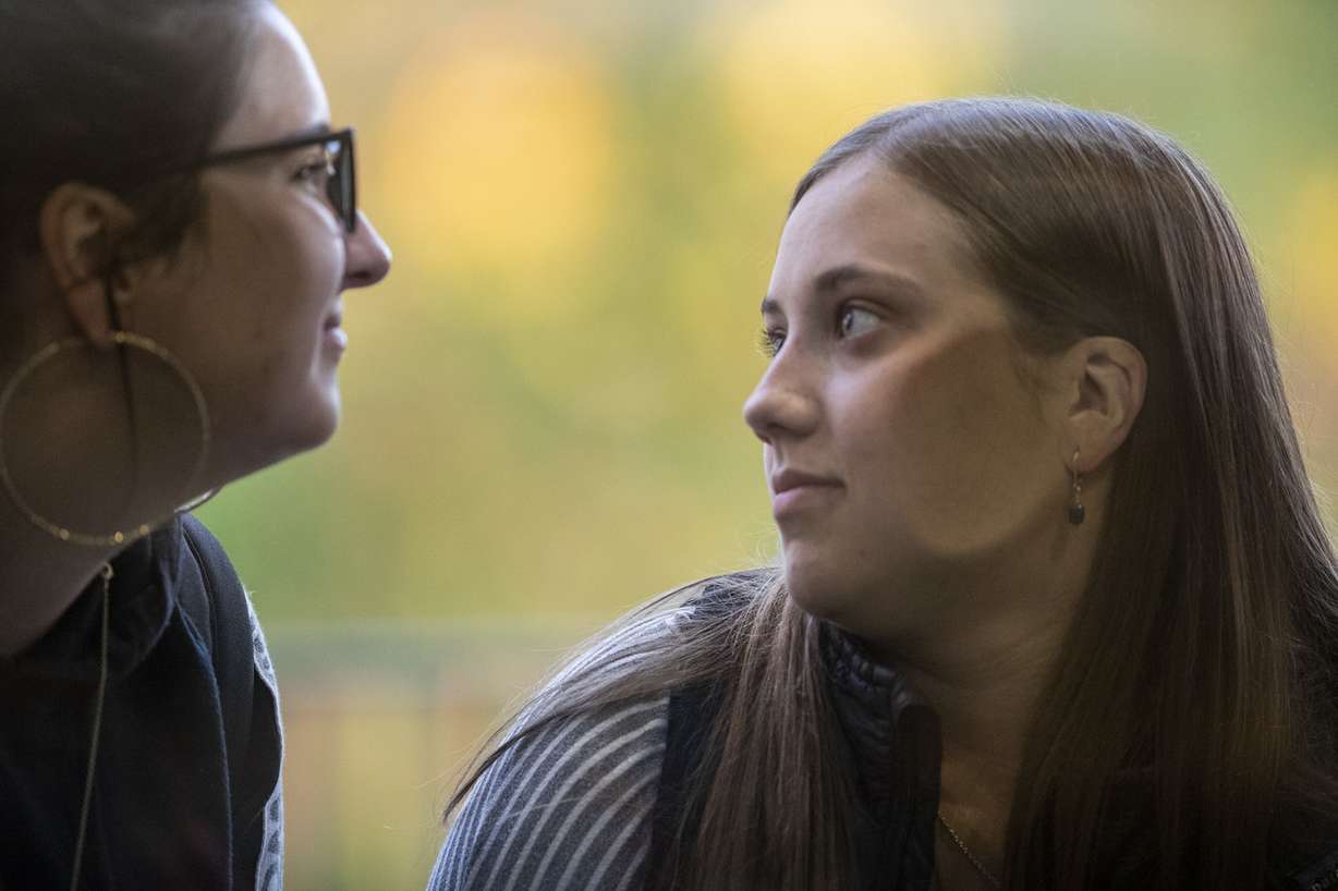 Two young women push their ears to the glass trying to hear Anita Hill speakimg to a capacity crowd at the Obert C. and Grace A. Tanner Humanities Center at the University of Utah in Salt Lake City on Wednesday, Sept. 26, 2018. (Photo: Scott G Winterton, KSL)