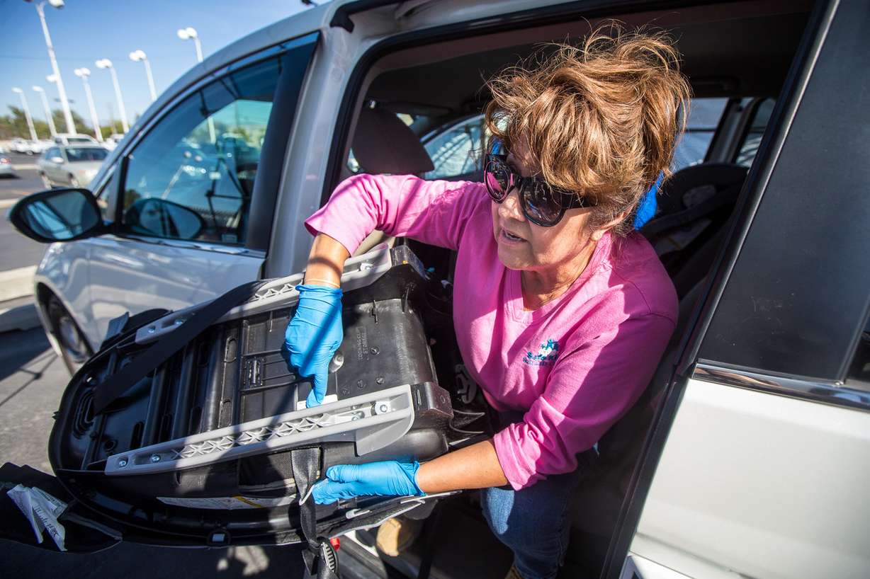 Child passenger safety technician May Romo helps adjust a car seat during a car seat checkup event at Gus Paulos Chevrolet in West Valley City on Friday, Sept. 28, 2018. (Photo: Qiling Wang, Deseret News)
