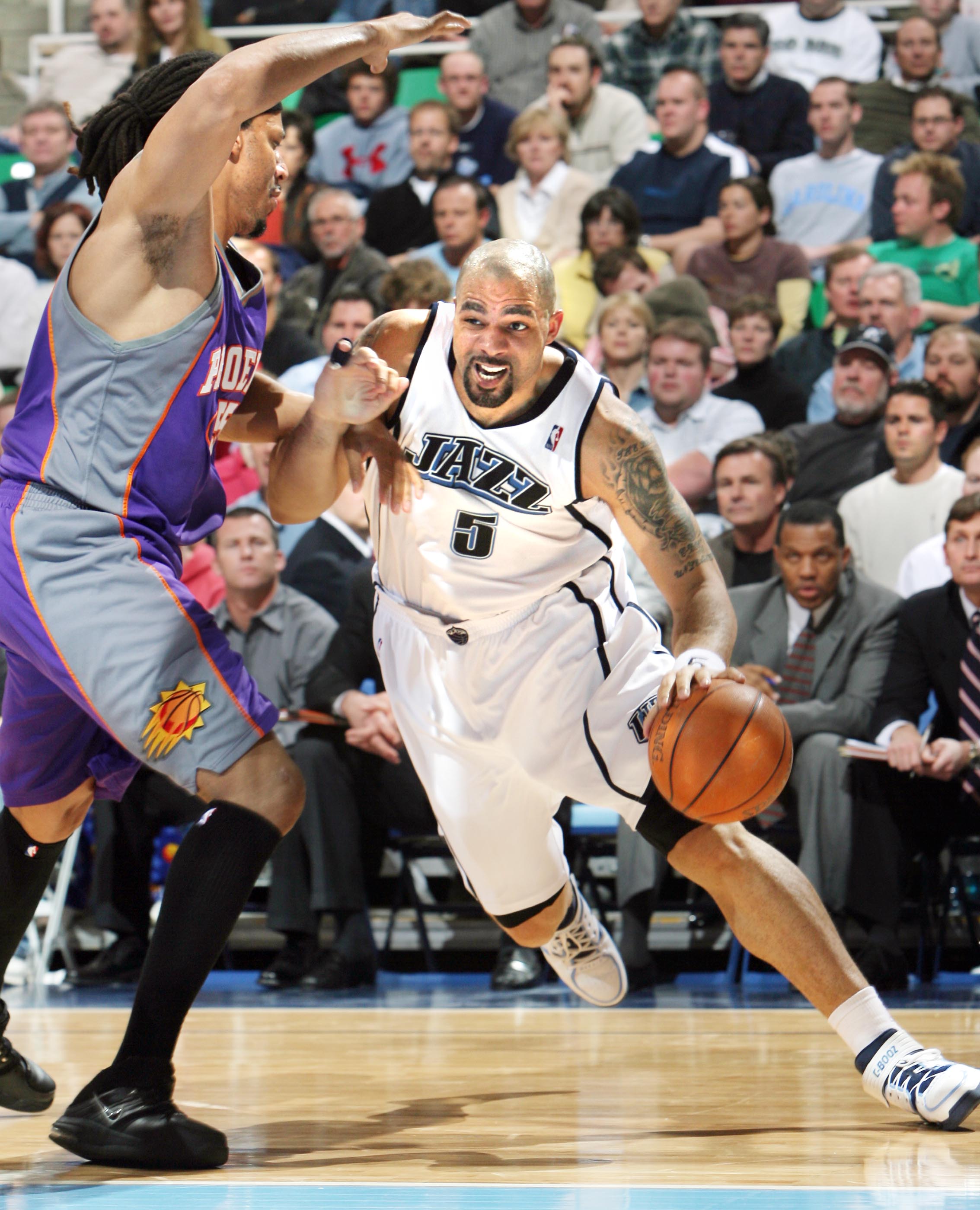 Utah Jazz's #5 Carlos Boozer drives under the hoop with Phoenix's #55 Brian Grant tries to defend in action at the Delta Center Tuesday March 21, 2006. (Photo: Scott G. Winterton, Deseret News)
