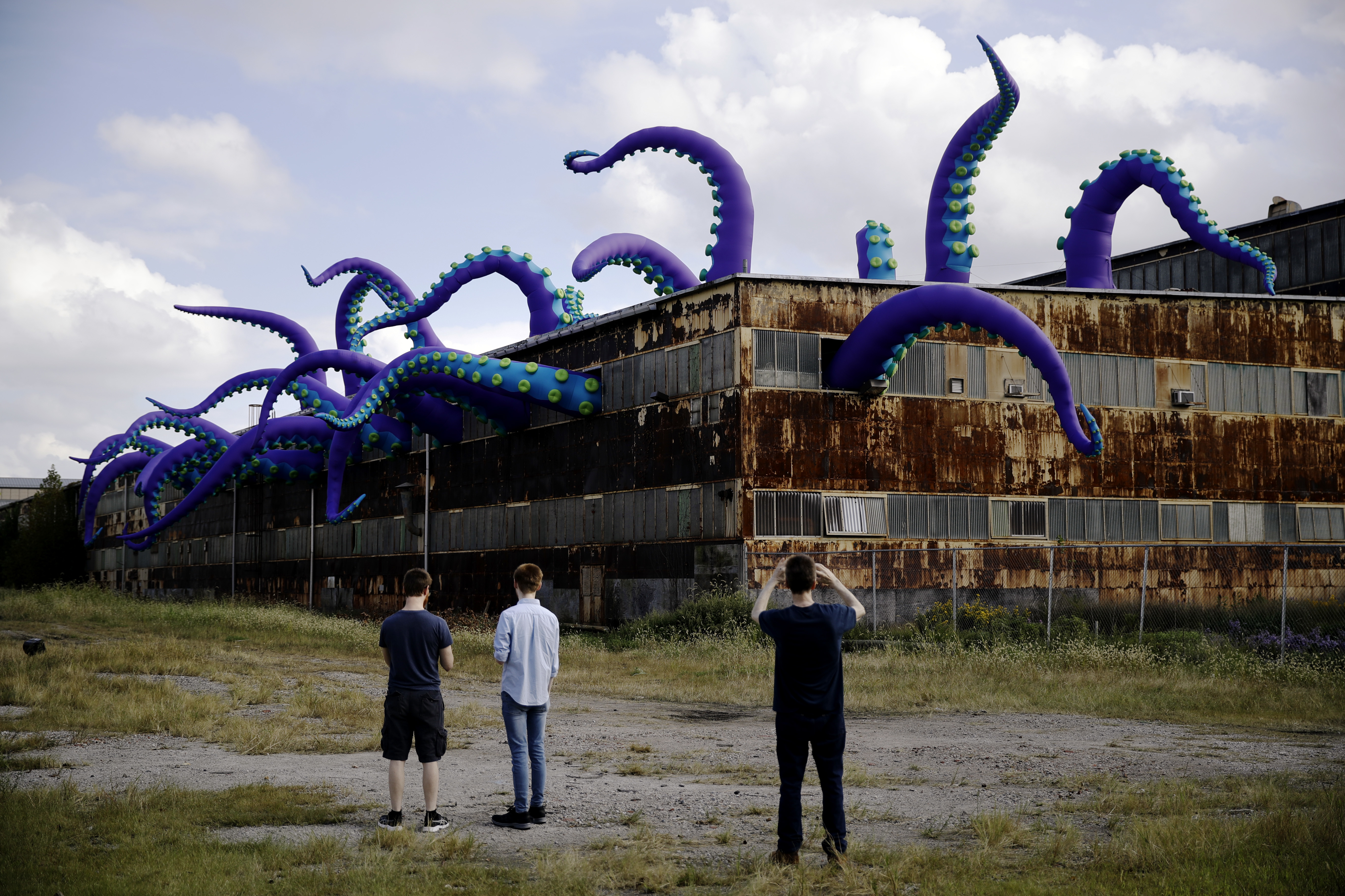 Inflatable sea monster takes over a rusting warehouse