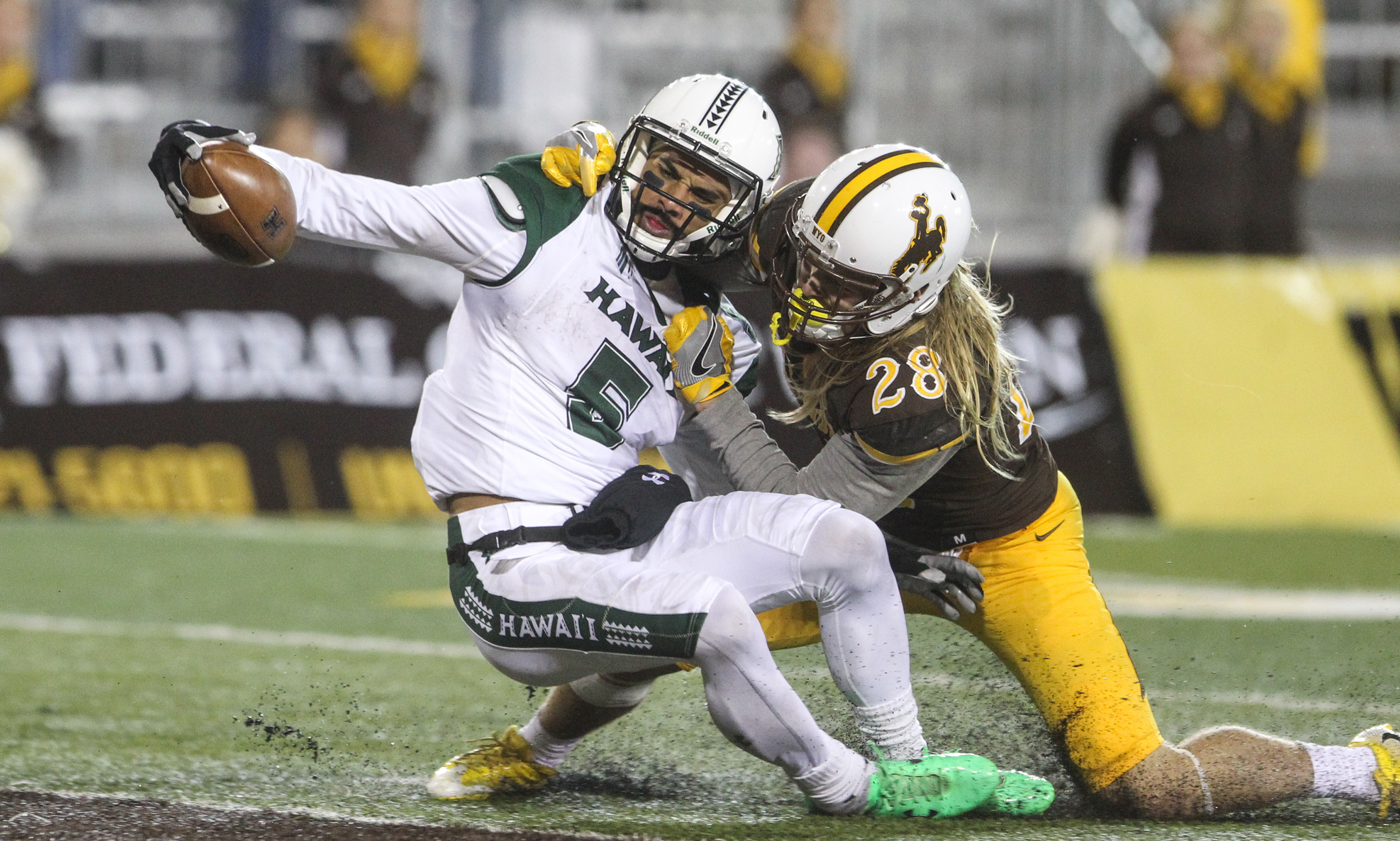 Hawaii wide receiver John Ursua (5) attempts to place the ball on the goal line as he is tackled by Wyoming safety Andrew Wingard (28) during the second half of an NCAA college football game in Laramie, Wyo., Saturday, Sept. 23, 2017. (Photo: Shannon Broderick, AP)