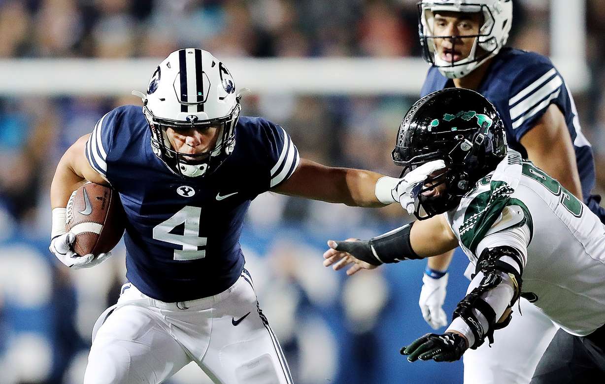 Brigham Young Cougars running back Lopini Katoa (4) tries to stiff-arm Hawaii Warriors defensive lineman Kaimana Padello (96) as BYU and Hawaii play at LaVell Edwards Stadium in Provo on Saturday, Oct. 13, 2018. (Photo: Scott G Winterton, Deseret News)