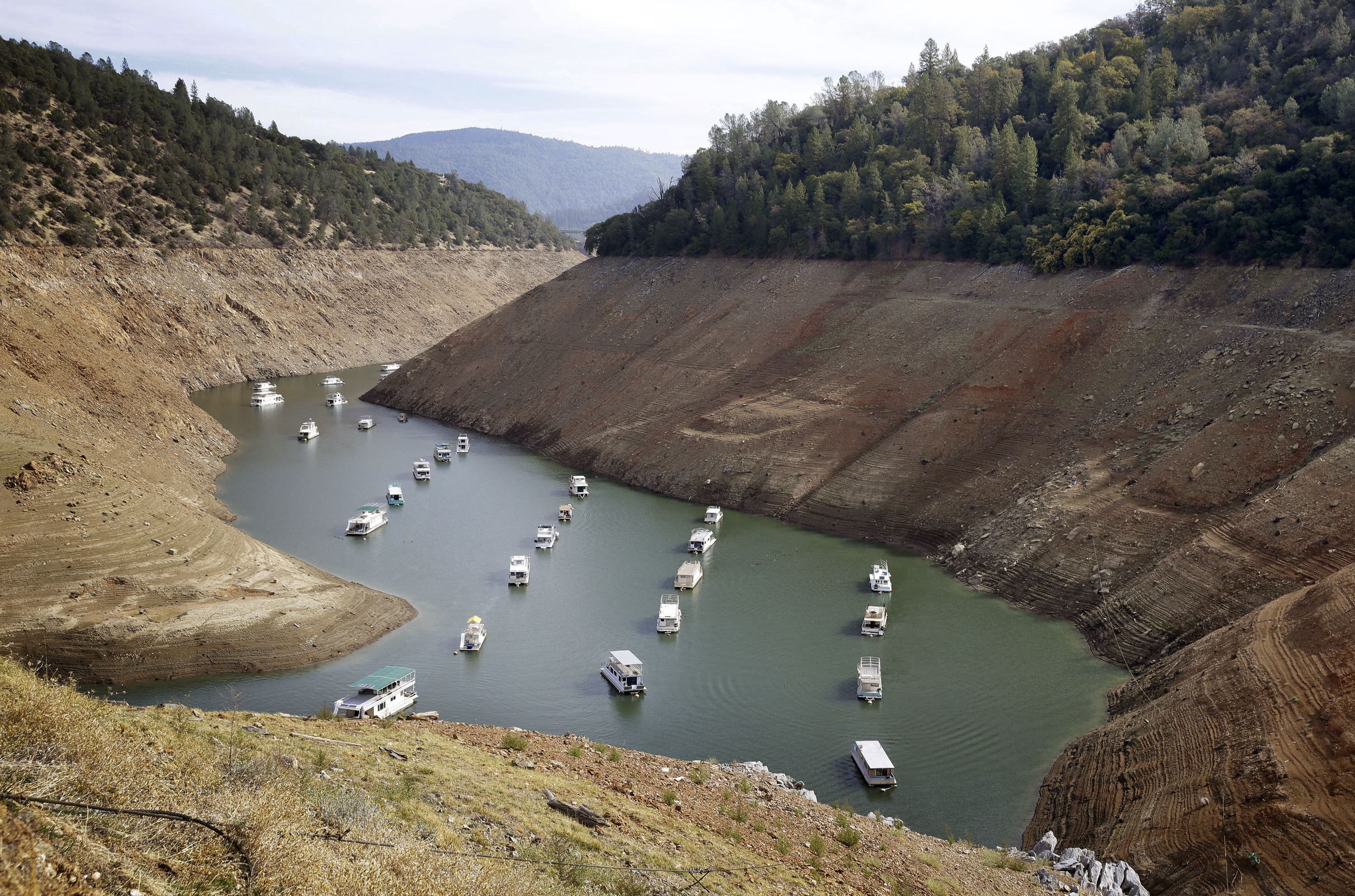 In this Oct. 30, 2014, file photo, houseboats float in the drought-lowered waters of Oroville Lake near Oroville, Calif. (AP Photo/Rich Pedroncelli, File)