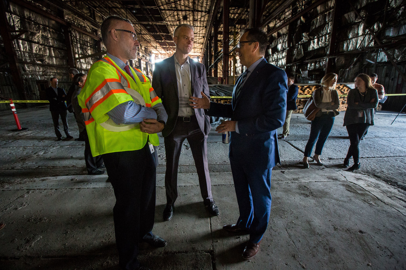 Utah House Speaker Greg Hughes, right, talks to Dave Goeres, Utah Transit Authority safety officer, and Matt Sibul, UTA director of government relations, inside a century-old building that was once used as Denver & Rio Grande’s locomotive shop in Salt Lake City on Monday, Oct. 22, 2018. Photo: Qiling Wang, KSL