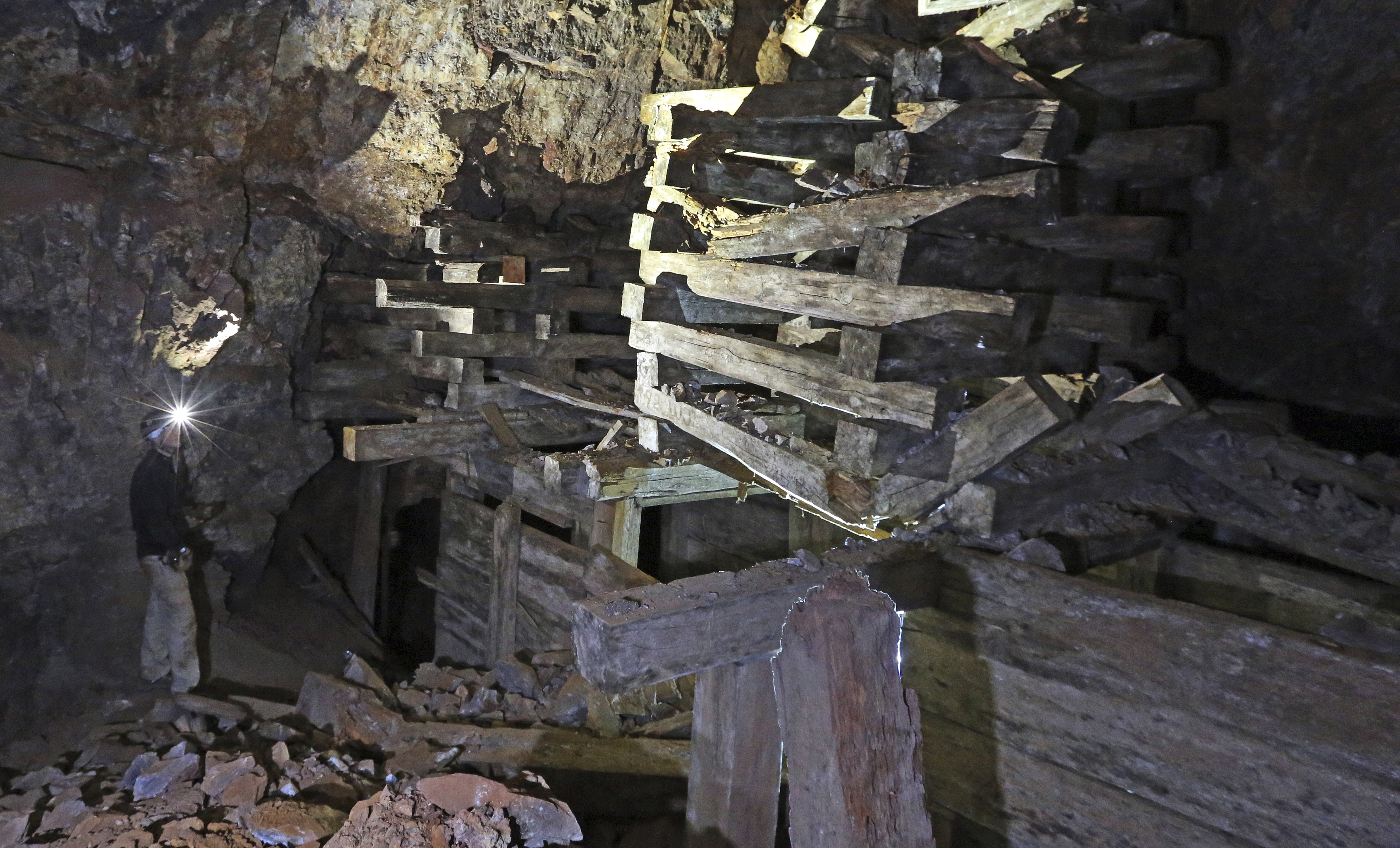 In this Aug. 26, 2018, photo, Jeremy MacLee explores a mine near Eureka, Utah. Underneath the mountains and deserts of the U.S. West lie hundreds of thousands of abandoned mines. Still, not everyone wants to see the mines closed. "Nobody has walked the path you're walking for 100 years," said MacLee, who uses old mining documents and high-tech safety equipment to find and explore forgotten holes, mostly in Utah. He also lends his expertise to searches for missing people. (AP Photo/Rick Bowmer)