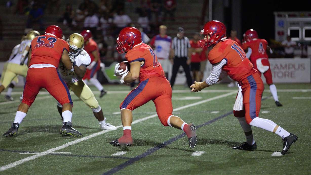 Dixie State running back Sei-J Lauago, center, takes a handoff from quarterback Trent Darms, right, in the second half of DSU's 51-47 win over South Dakota Mines. The Trailblazers will open their first season in Division I on Feb. 27 against Tarleton State.