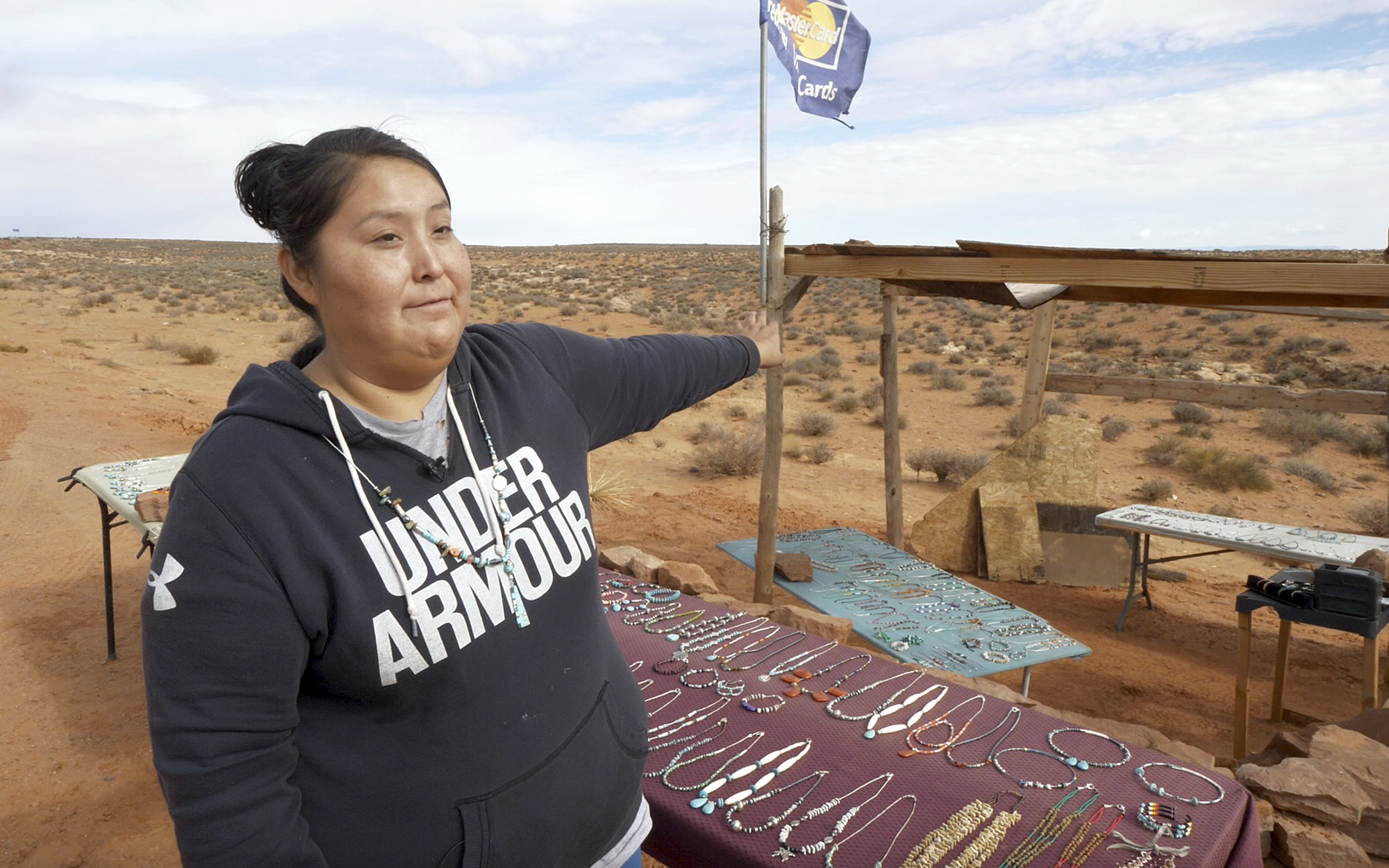 In this Thursday, Oct. 25, 2018, photo, Tammie Nakai displays her jewelry at her stand in Monument Valley, Utah, where tourists stand the highway to recreate a famous running scene from the movie "Forest Gump." (AP Photo/Rick Bowmer)