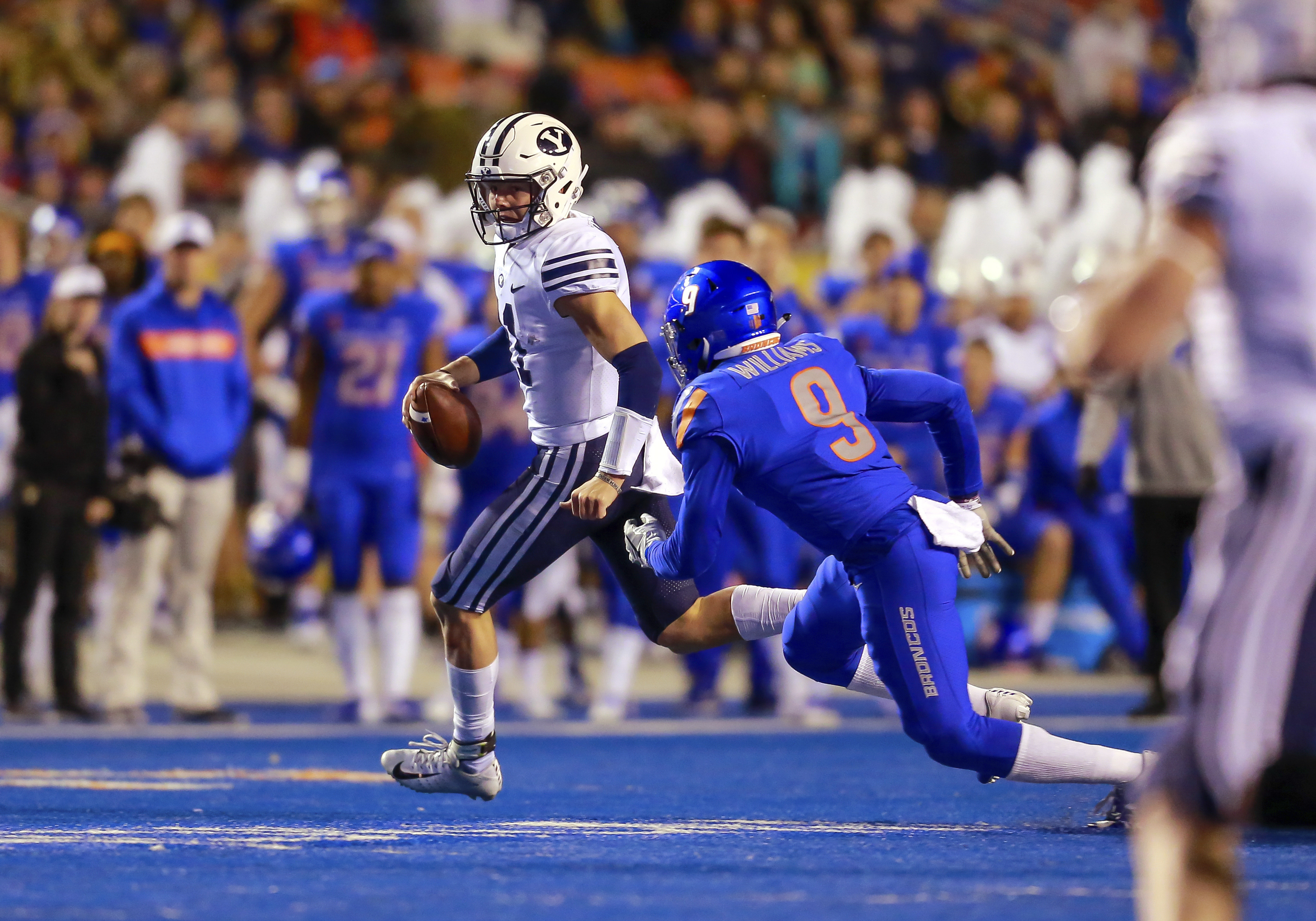 BYU quarterback Zach Wilson (11) scrambles away from Boise State linebacker Desmond Williams (9) during the first half of an NCAA college football game Saturday, Nov. 3, 2018, in Boise, Idaho. (Steve Conner, AP Photo)