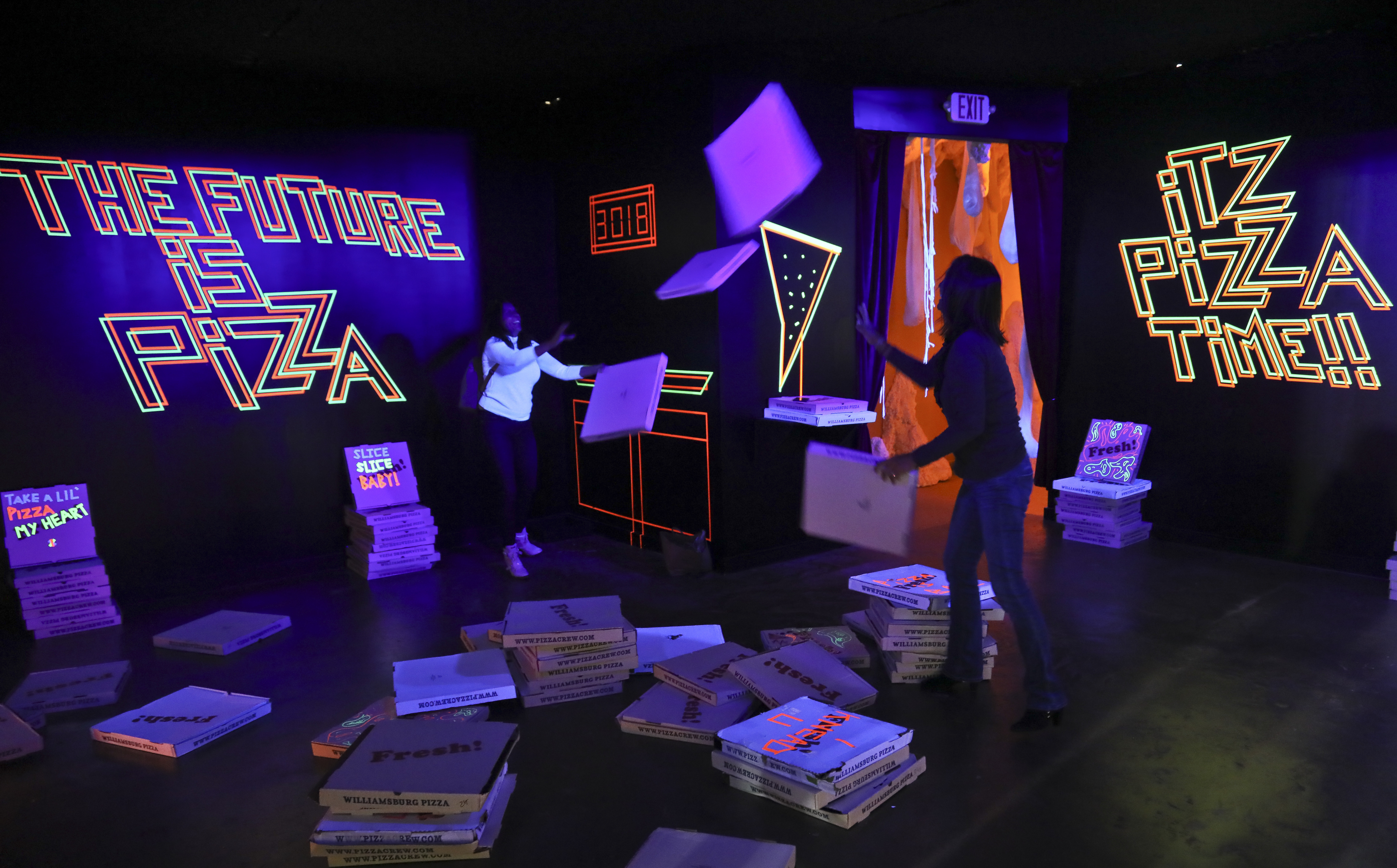This Nov. 2, 2018 photo shows a pizza box playroom created with neon lights and colorful fluorescent tape called "Gazoo," part of a group art exhibition celebrating pizza at The Museum of Pizza in New York. (AP Photo/Bebeto Matthews)