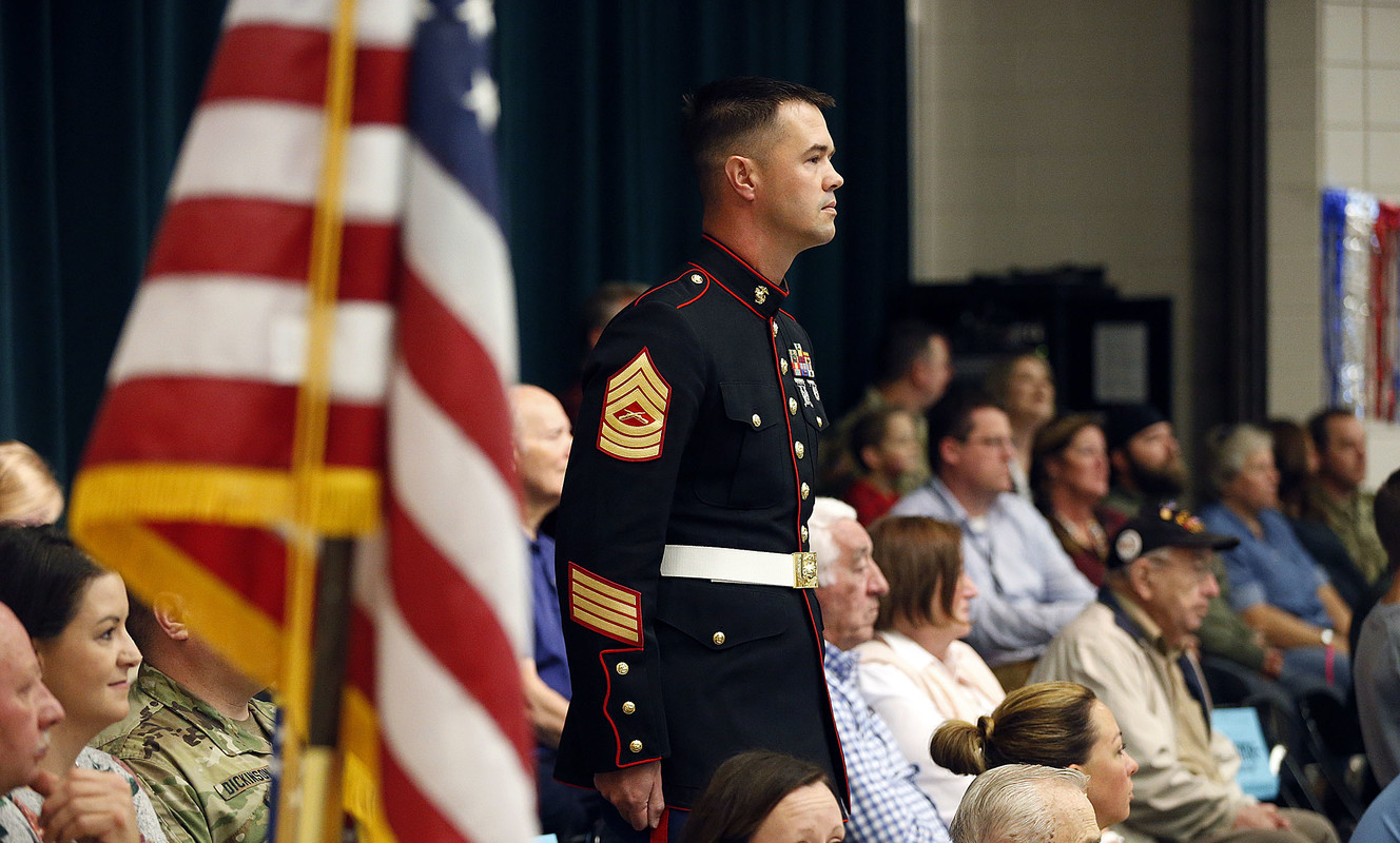 Sgt. Dustin Deaton, now serving in the Marines, stands as students sing during an assembly honoring veterans at Midas Creek Elementary in Riverton on Monday, Nov. 12, 2018. (Photo: Ravell Call, KSL)