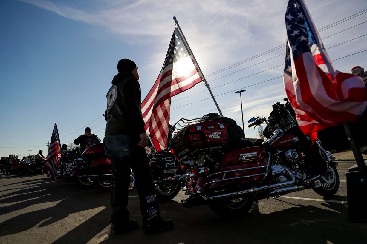 Patrick Carver, a state chaplain with the Patriot Guard Riders, adjusts an American flag on the back of his motorcycle as he and other riders wait to escort Maj. Brent Taylor's casket from Roland R. Wright Air National Guard Base in Salt Lake City on Wednesday, Nov. 14, 2018. (Photo: Spenser Heaps, KSL)