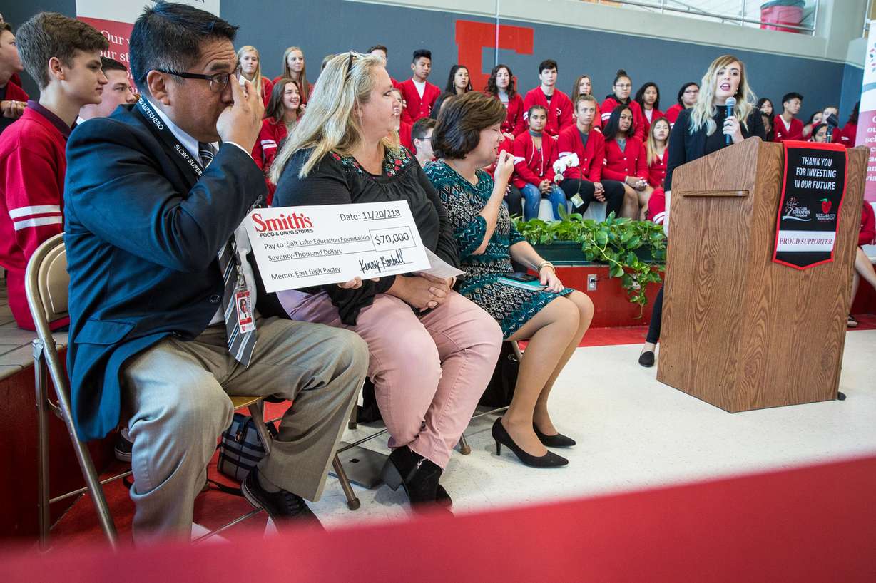 James Yapias, director of Salt Lake Education Foundation, left, receives a check from Smith's Food and Drug Stores during the opening East High School's Leopard Stash food pantry in Salt Lake City on Tuesday, Nov. 20, 2018. (Photo: Qiling Wang, KSL)