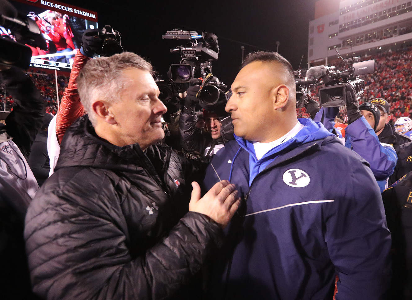 FILE - Utah Utes head coach Kyle Whittingham and Brigham Young Cougars head coach Kalani Sitake hug at the end of the game as Utah defeats BYU at Rice Eccles Stadium in Salt Lake City on Sunday, Nov. 25, 2018. Utah won 35-27. (Photo: Scott G Winterton, KSL)