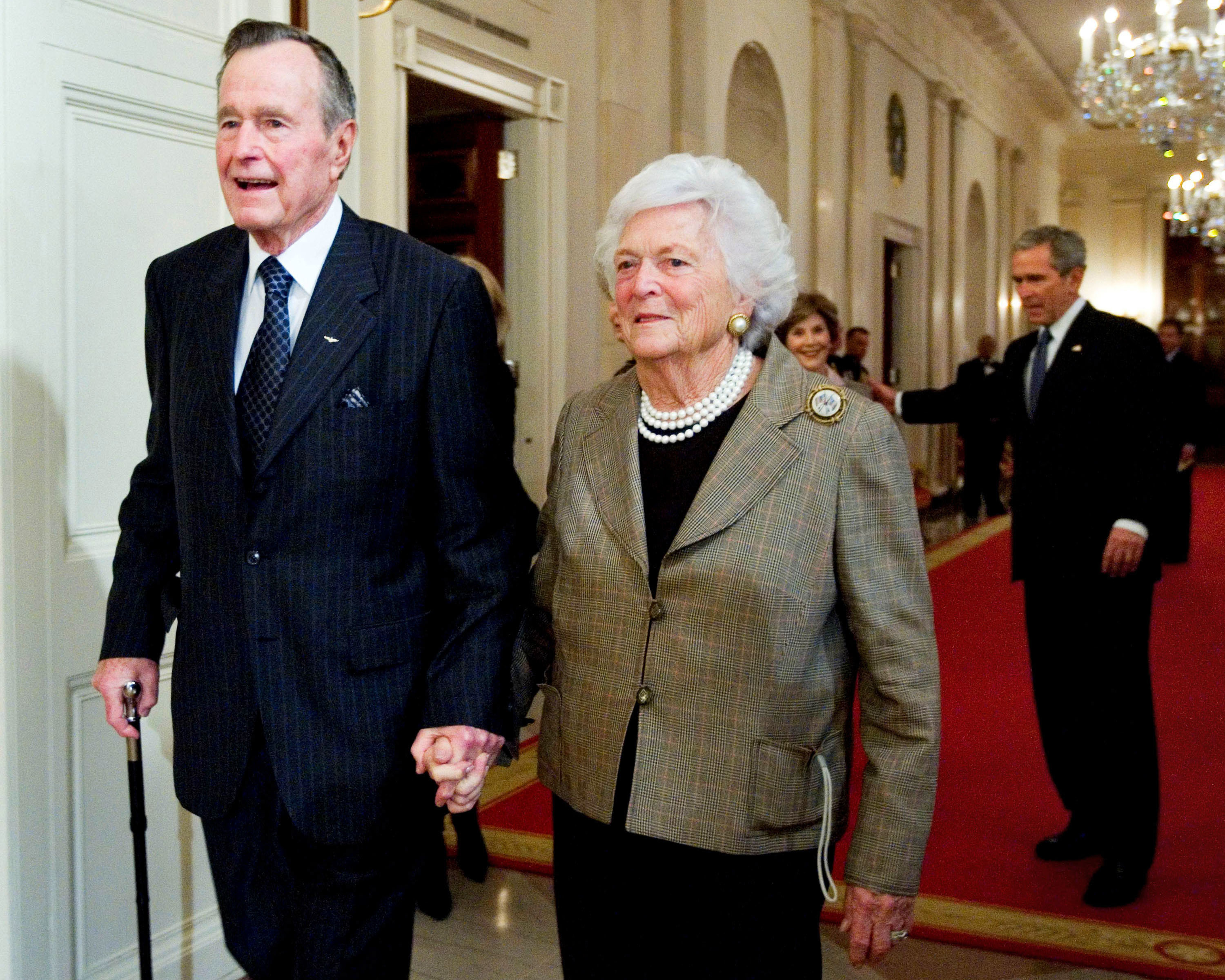 FILE - In this Jan. 7, 2009, file photo, former President George H.W. Bush, left, walks with his wife, Barbara Bush, followed by their son, President George W. Bush, and first lady Laura Bush to a reception in honor of the Points of Light Institute in the East Room at the White House in Washington. (AP Photo/Manuel Balce Ceneta, File)
