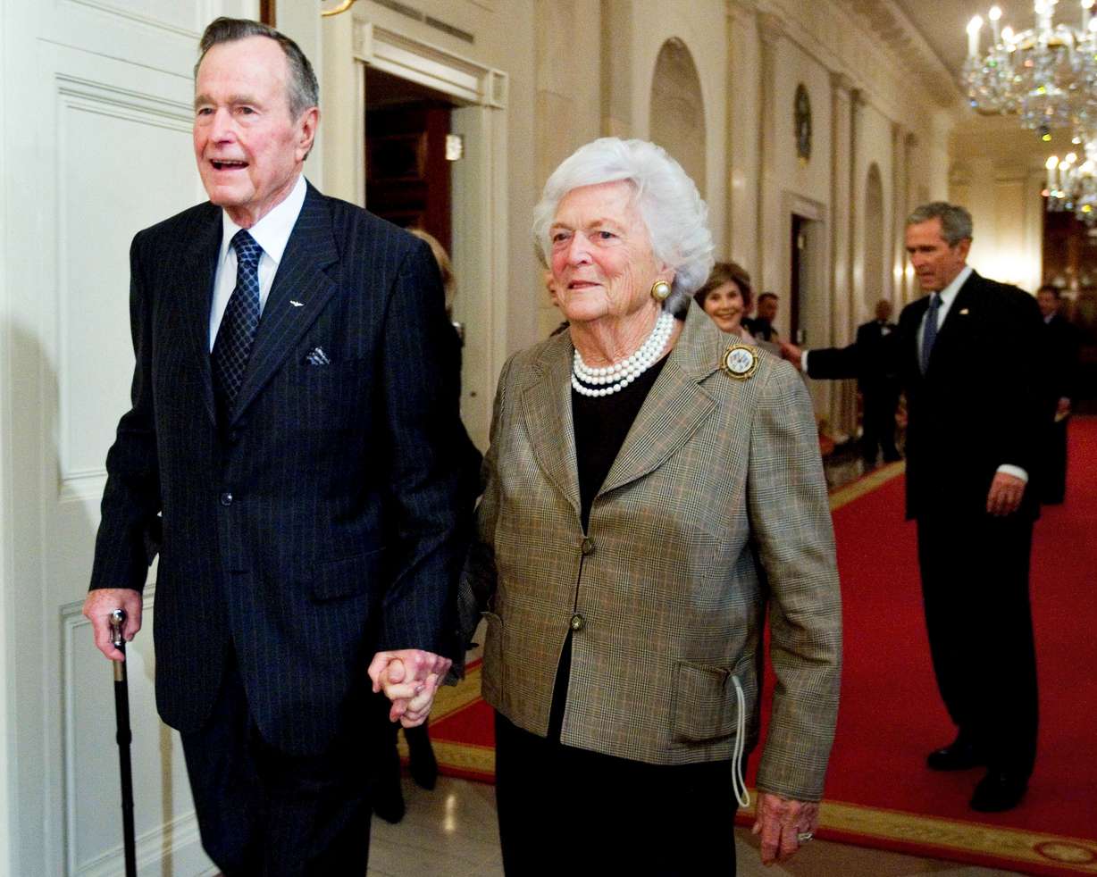 FILE - In this Jan. 7, 2009, file photo, former President George H.W. Bush, left, walks with his wife, Barbara Bush, followed by their son, President George W. Bush, and first lady Laura Bush to a reception in honor of the Points of Light Institute in the East Room at the White House in Washington. (AP Photo/Manuel Balce Ceneta, File)