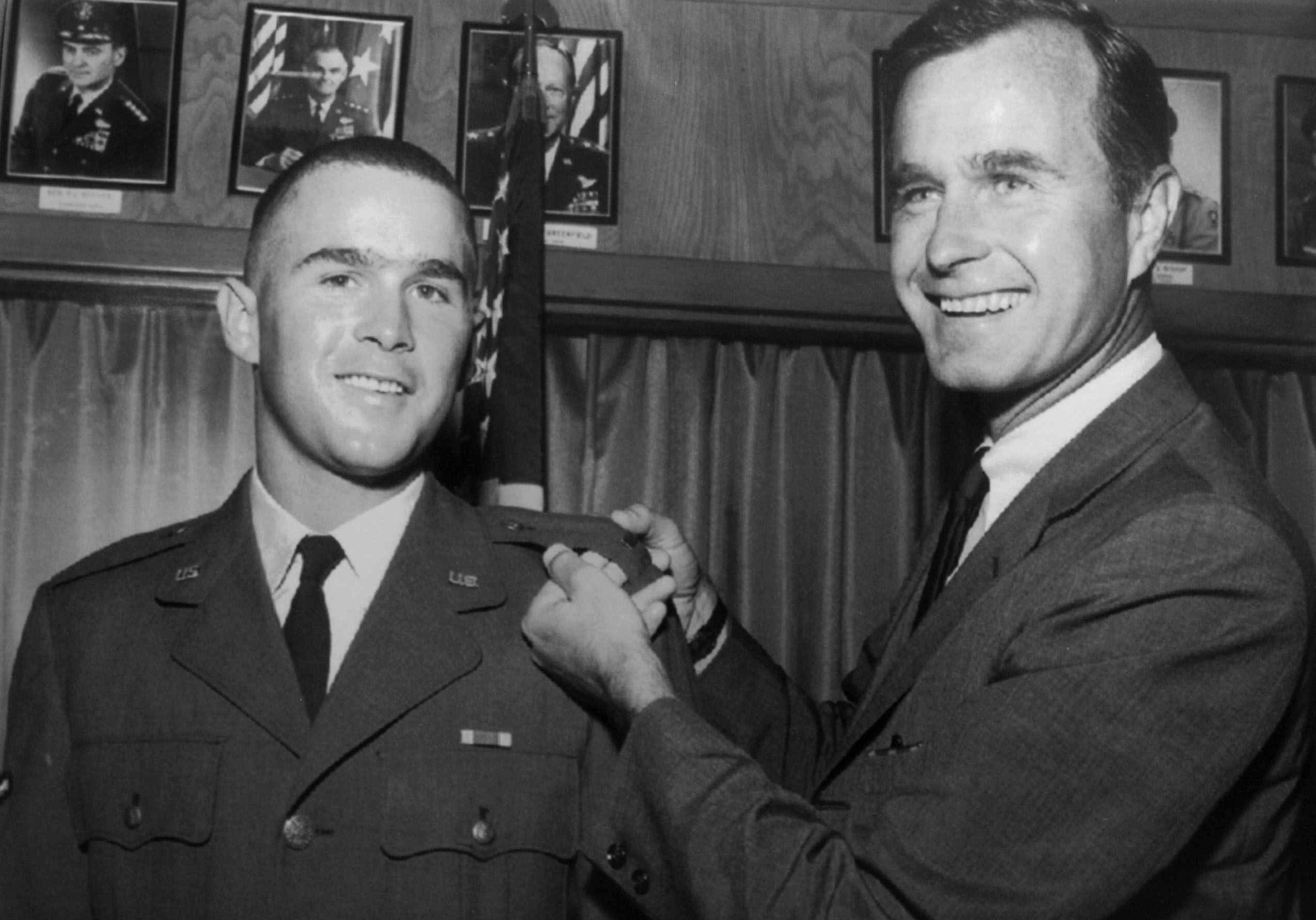 FILE - In this 1968 file photo provided by the Texas National Guard, George H.W. Bush, right, is about to pin a lieutenant bar on his son, George W. Bush, after the younger Bush was made an officer in the Texas Air National Guard in Ellington Field, Texas. (AP Photo, File)