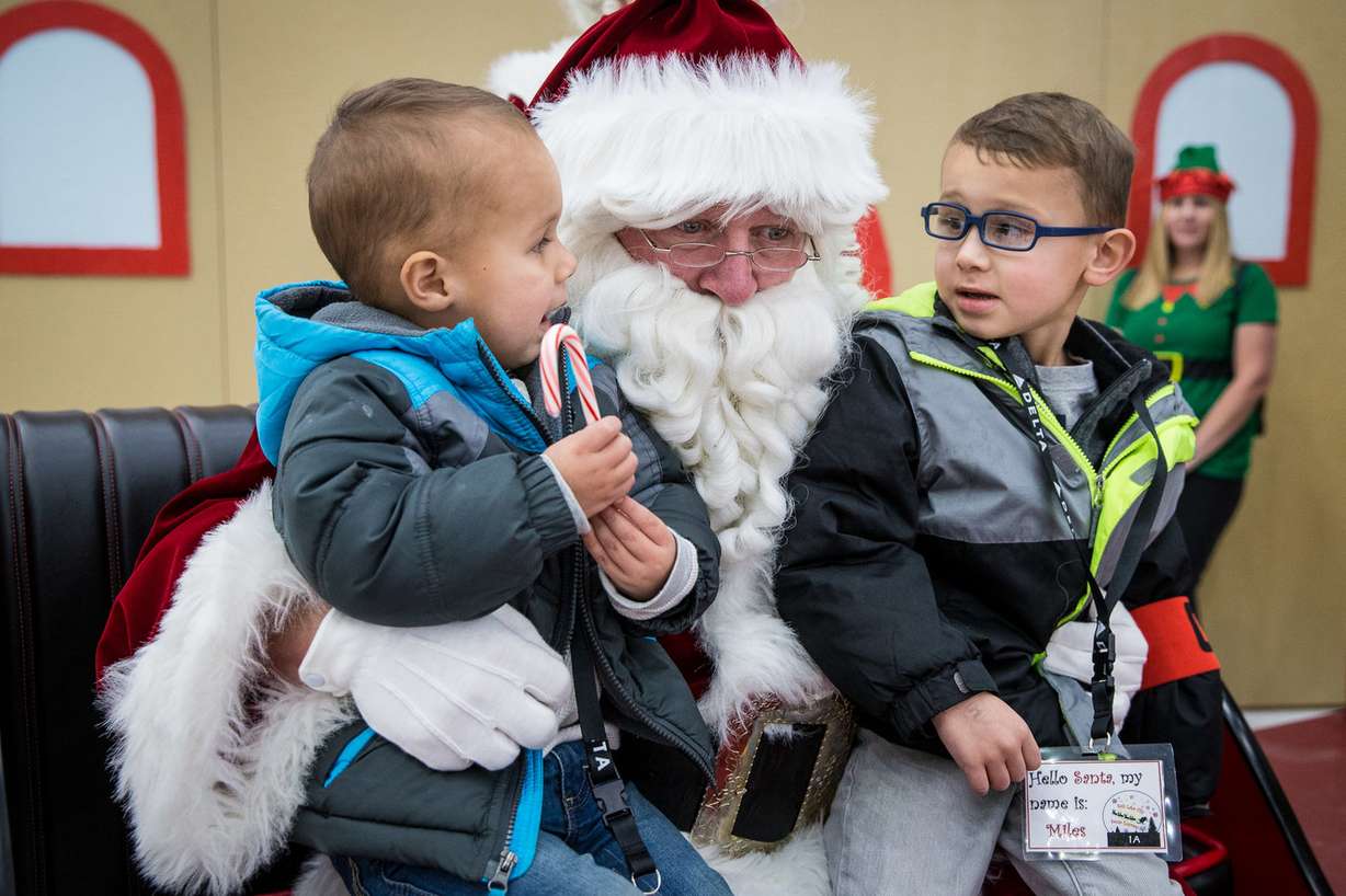 Santa Claus talks to Corde Lamb, 2, left, and Miles Lamb, 4, at the Delta Air Lines hangar in Salt Lake City, which was transformed into Santa’s Winter Wonderland on Saturday, Dec. 1, 2018. (Photo: Qiling Wang, KSL)