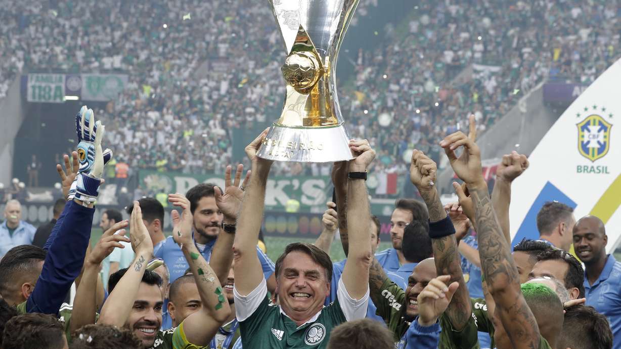 Jeers and cheers as Bolsonaro hands trophy to Palmeiras