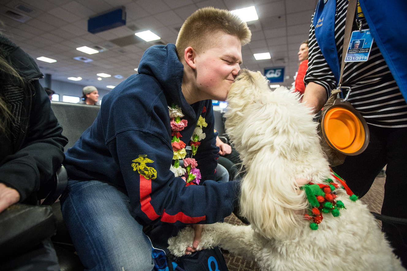 John "Jack" May, 17, kisses Annie, a therapy dog, during the annual Snowball Express, an event for children and spouses of fallen military heroes, at the Salt Lake City International Airport on Saturday, Dec. 8, 2018. (Photo: Qiling Wang, KSL)