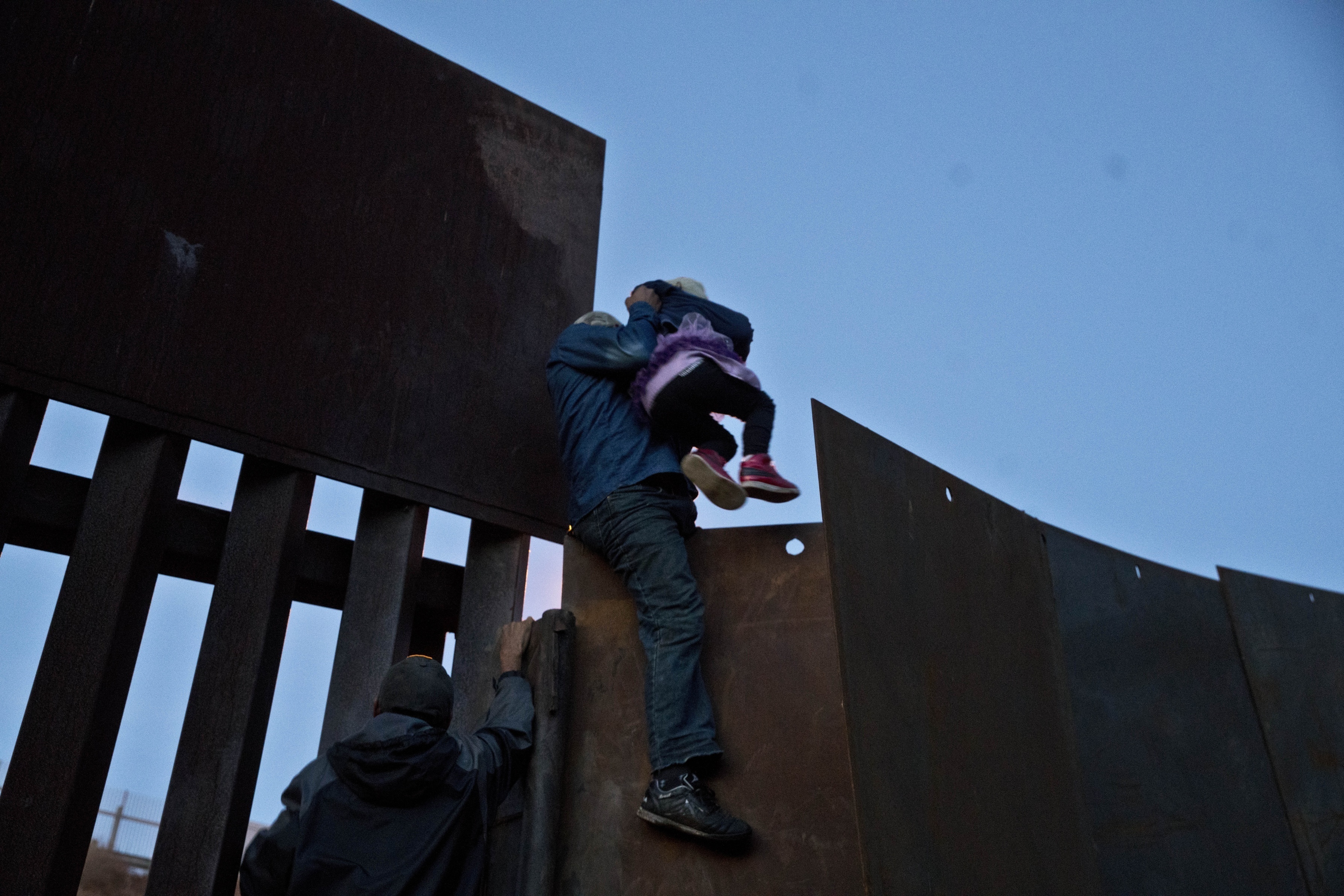 AP PHOTOS: Migrants in Tijuana trickling over and under wall