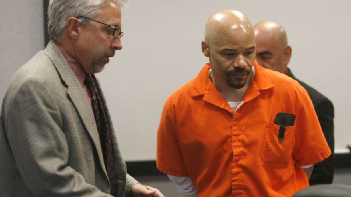 Defense lawyer Mark Moffat, left, clears a spot at the table for death row inmate Douglas Stewart Carter during a hearing in Provo's 4th District Court in October 2007. Utah's attorney general plans to file an appeal challenging a judge's decision to overturn a death penalty conviction three years after the state's Supreme Court ordered a new trial.