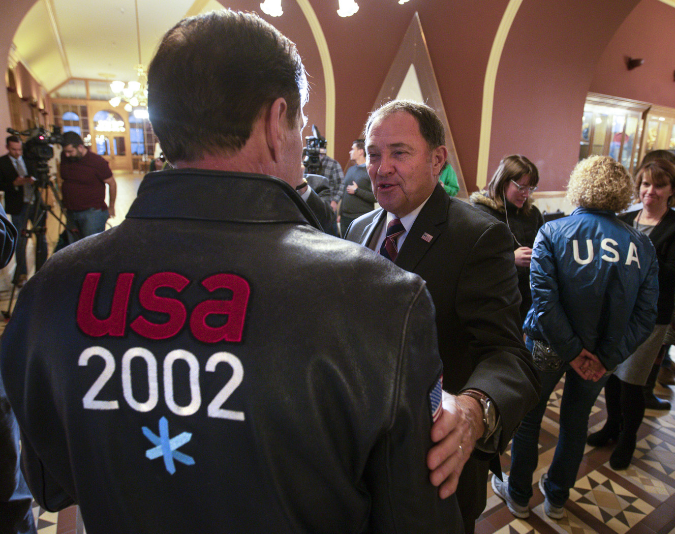 Former Utah Gov. Gary Herbert, center, talks with Fraser Bullock, chief operating officer of the 2002 Winter Games, at the Salt Lake City-County Building after the U.S. Olympic Committee selected Salt Lake City to bid on behalf of the United States, potentially for the 2030 Winter Games, on Friday, Dec. 14, 2018.