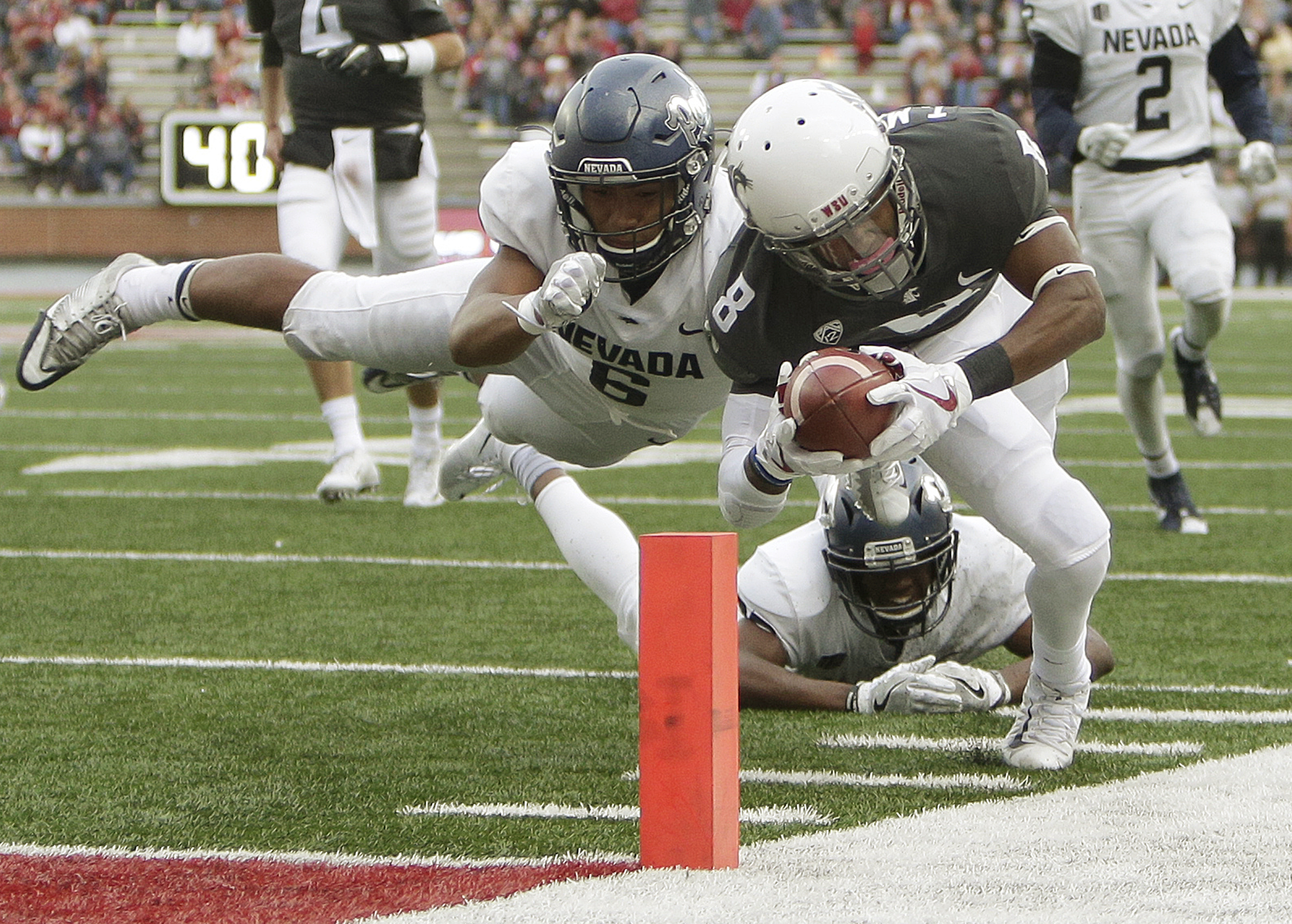 Washington State wide receiver Tavares Martin Jr. (8) dives for a touchdown while defended by Nevada's Nephi Sewell (6) during the second half of an NCAA college football game in Pullman, Wash., Saturday, Sept. 23, 2017. (Photo: Young Kwak, AP)