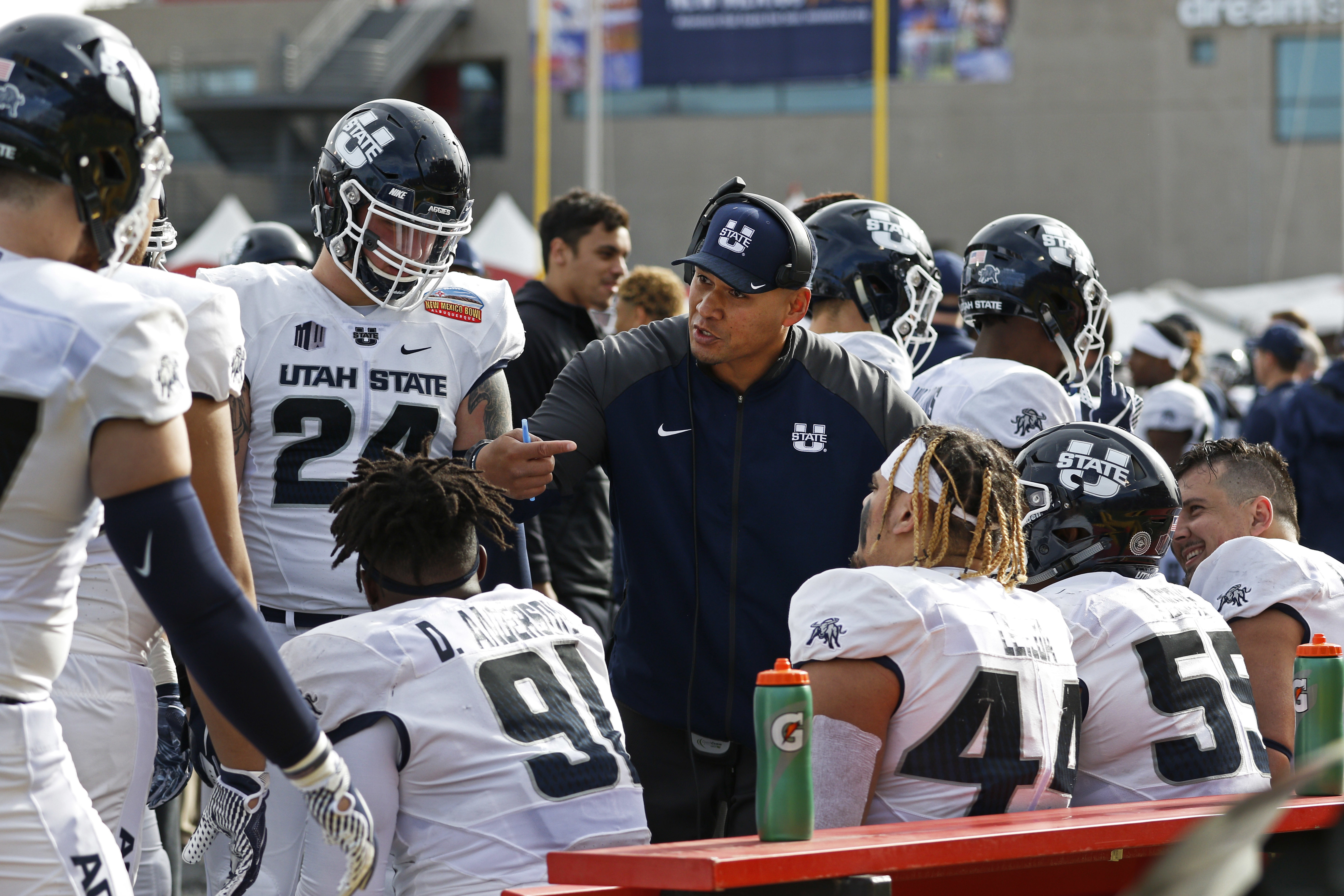 Utah State interim head coach Frank Maile, center, speaks to his players during a time out in the first half of the New Mexico Bowl NCAA college football game against North Texas in Albuquerque, N.M., Saturday, Dec. 15, 2018.