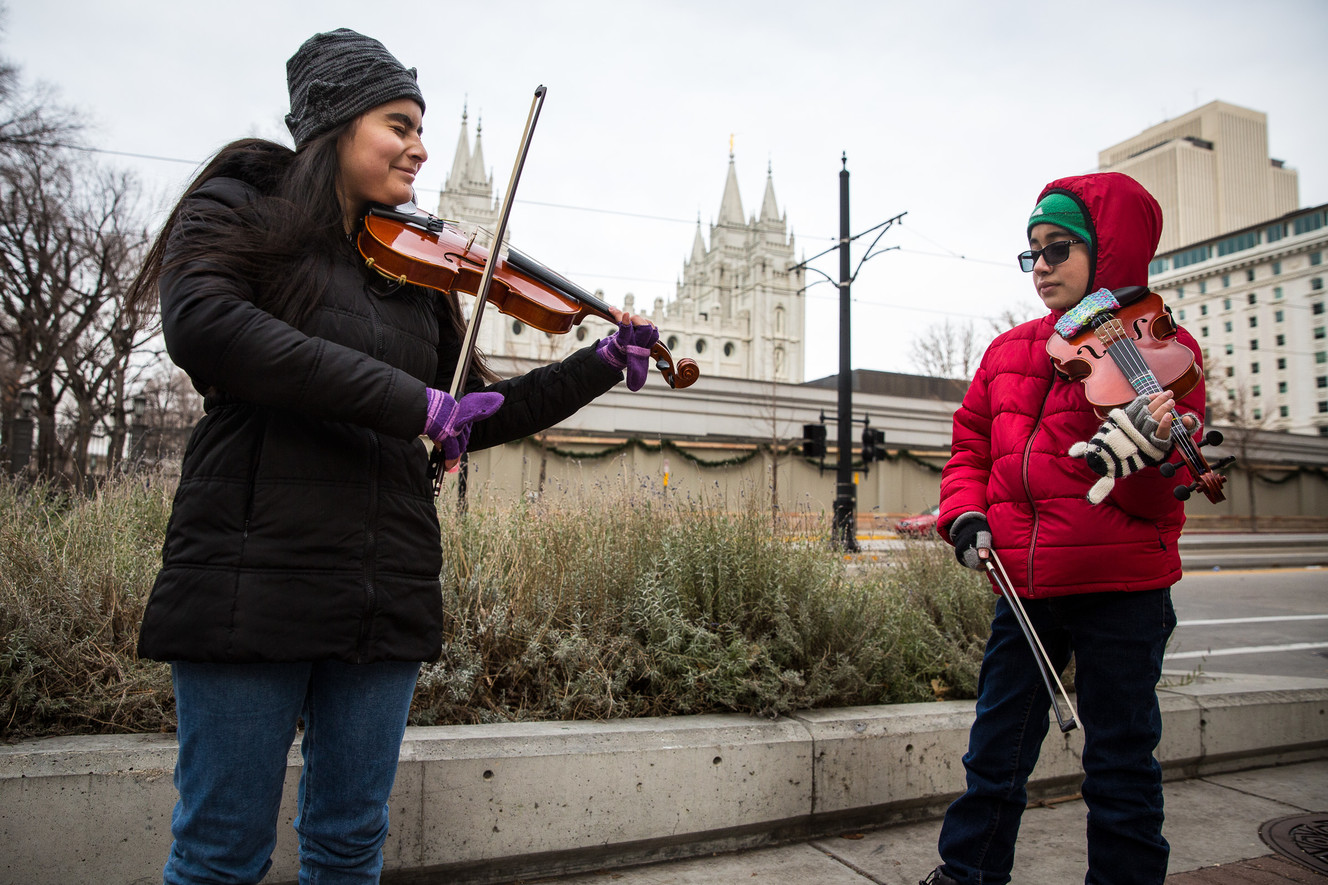 Tiffany Palacios, 14, left, and Brandon Palacios, 11, play violin near the Salt Lake Temple in Salt Lake City on Sunday, Dec. 23, 2018. (Photo: Qiling Wang, KSL)