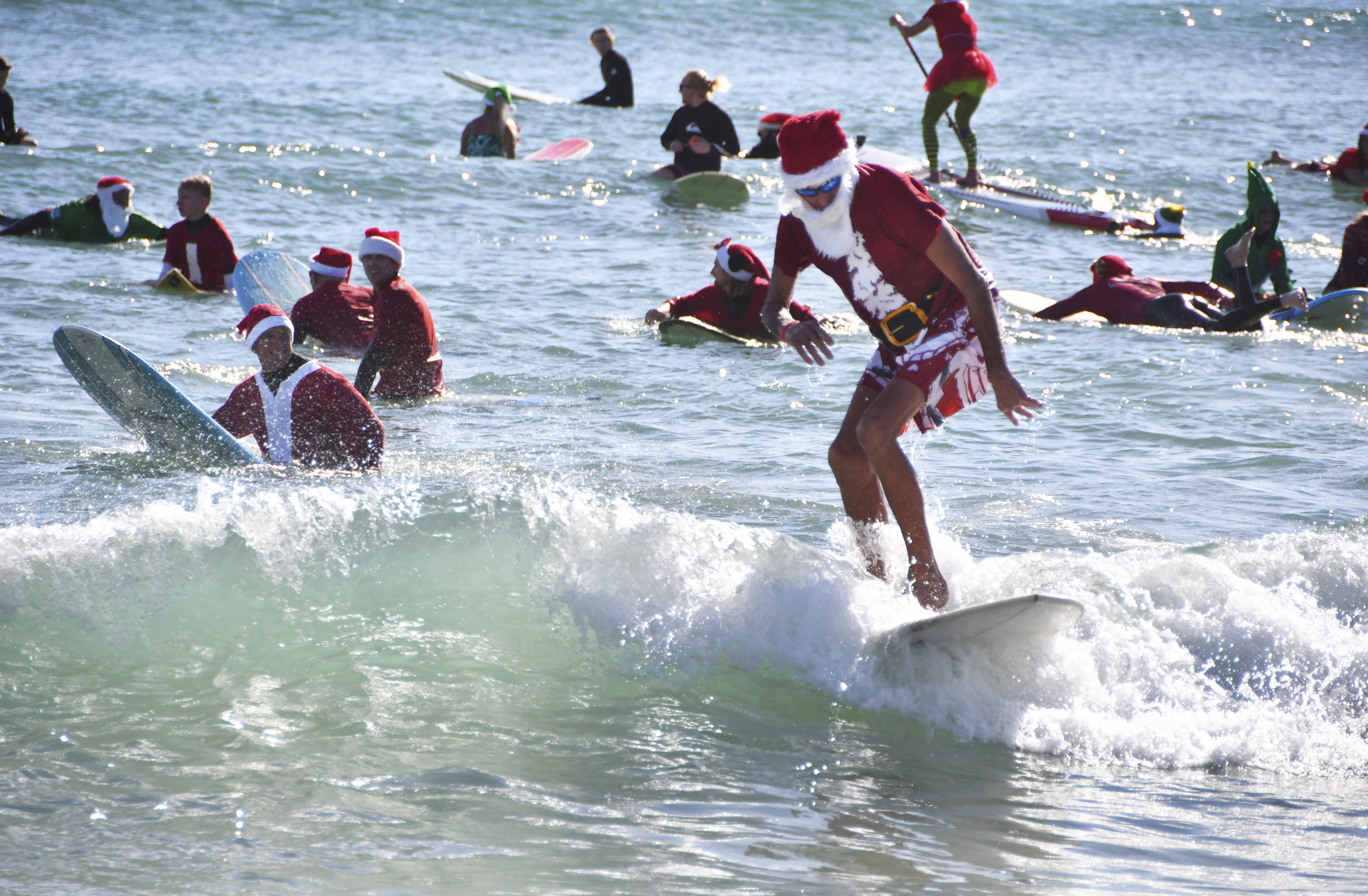 Hundreds of surfers in Santa suits ride waves in Florida