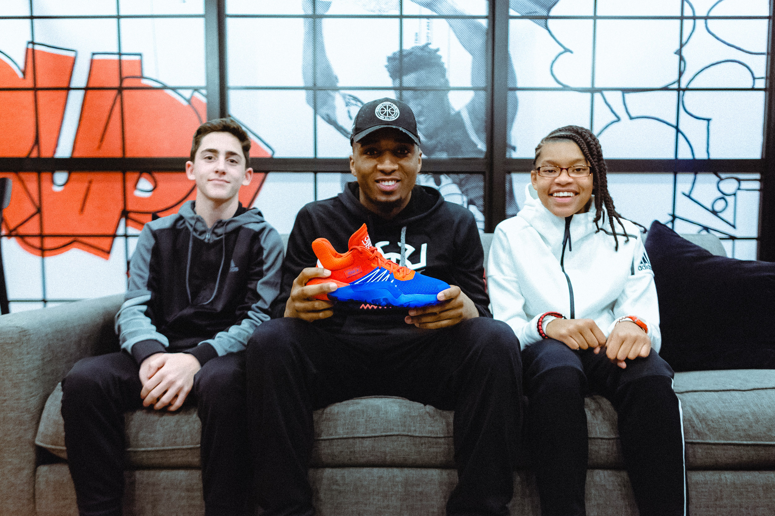 Donovan Mitchell holds the D.O.N. ISSUE #1 surrounded by two student reporters.