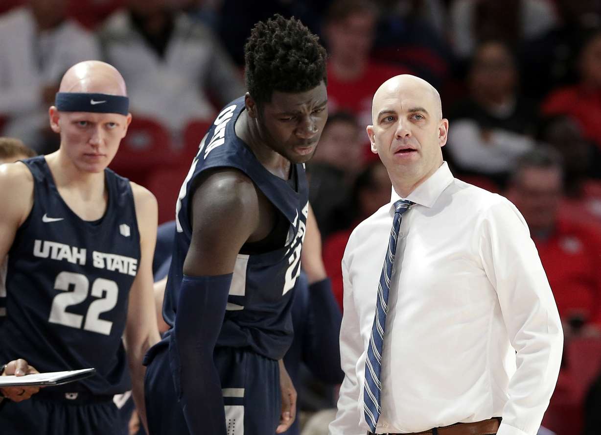 Utah State guard Brock Miller (22) looks on as center Neemias Queta, middle, talks with head coach Craig Smith during the first half of an NCAA college basketball game against Houston Thursday, Dec. 20, 2018, in Houston. (Photo: Michael Wyke, AP)